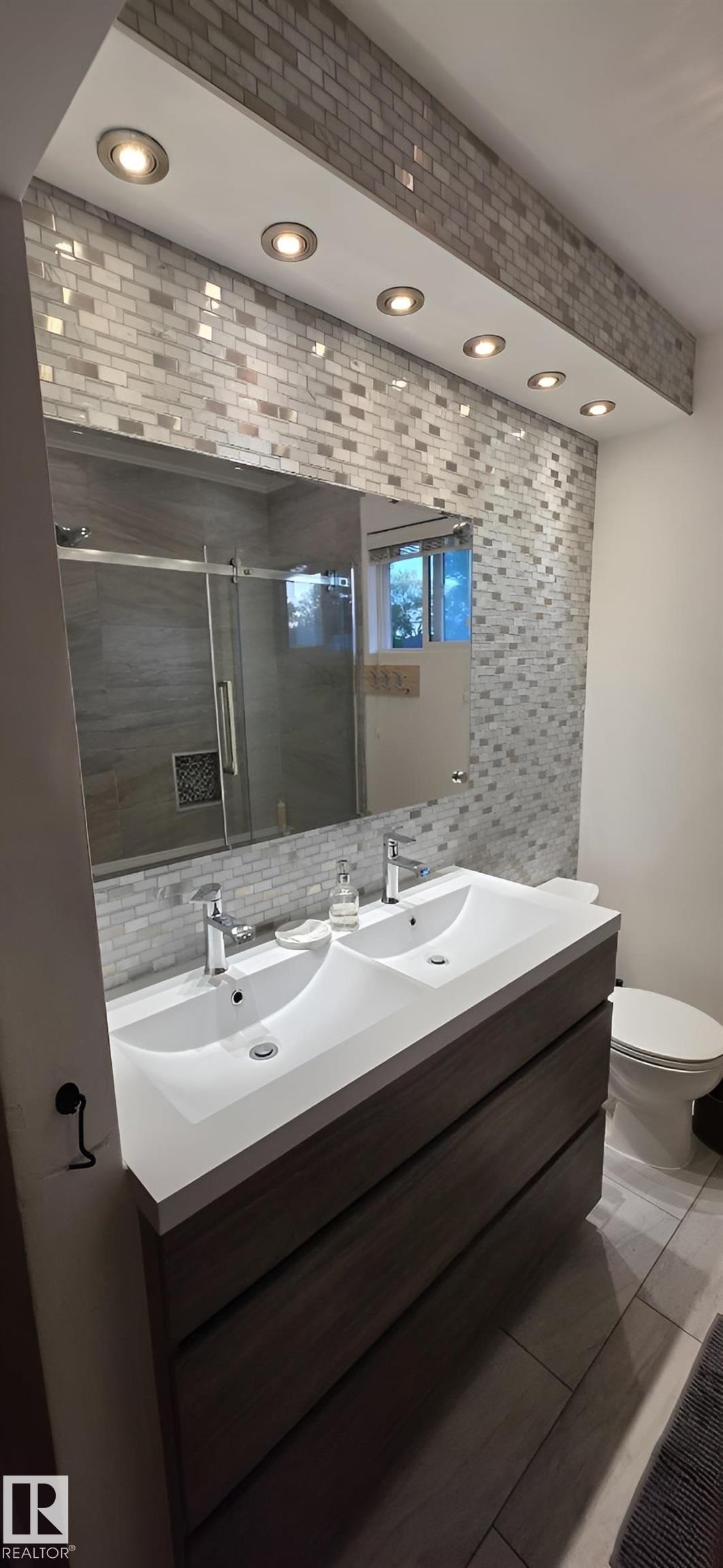 Contemporary bathroom featuring a floating double vanity with integrated sinks - 6704 93 Street, Edmonton, AB