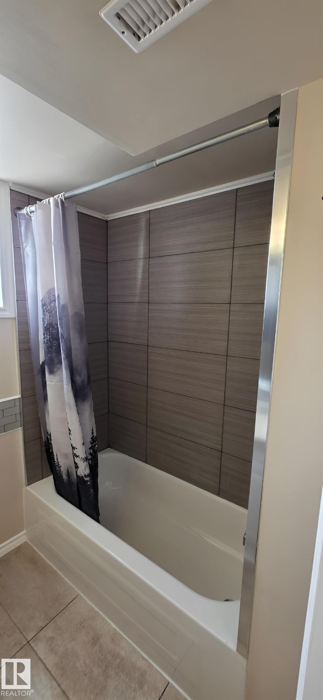 Bathtub featuring horizontal grey tiling, an integrated side window, and a tiled floor - 6704 93 Street, Edmonton, AB