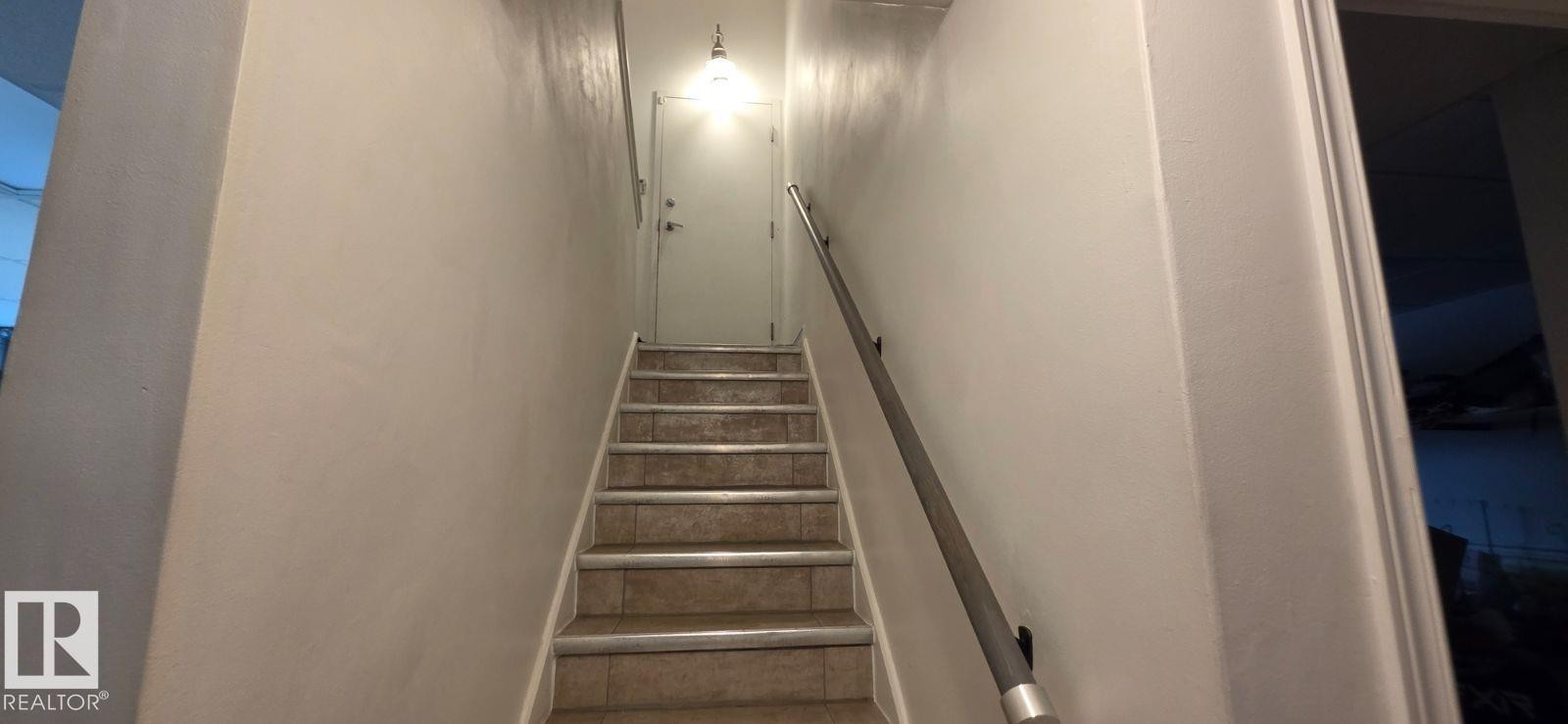 Tiled staircase with white risers and a metal handrail - 6704 93 Street, Edmonton, AB