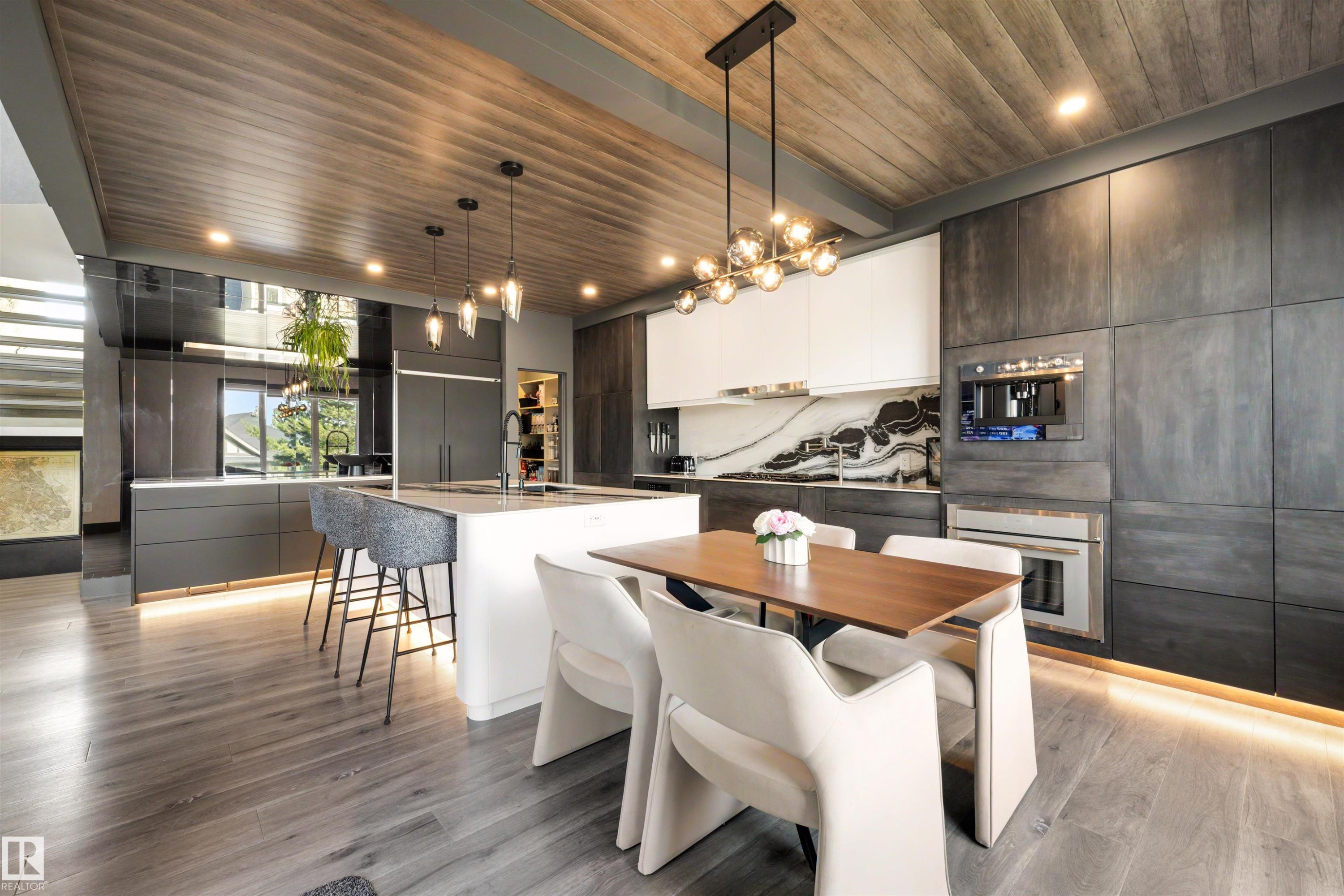 Contemporary kitchen featuring an expansive center island, integrated appliances, wood-finish plank flooring, a wood-finish ceiling, and a striking black and white backsplash - 4376 Mcclung Crescent Nw, Edmonton, AB - Indoor