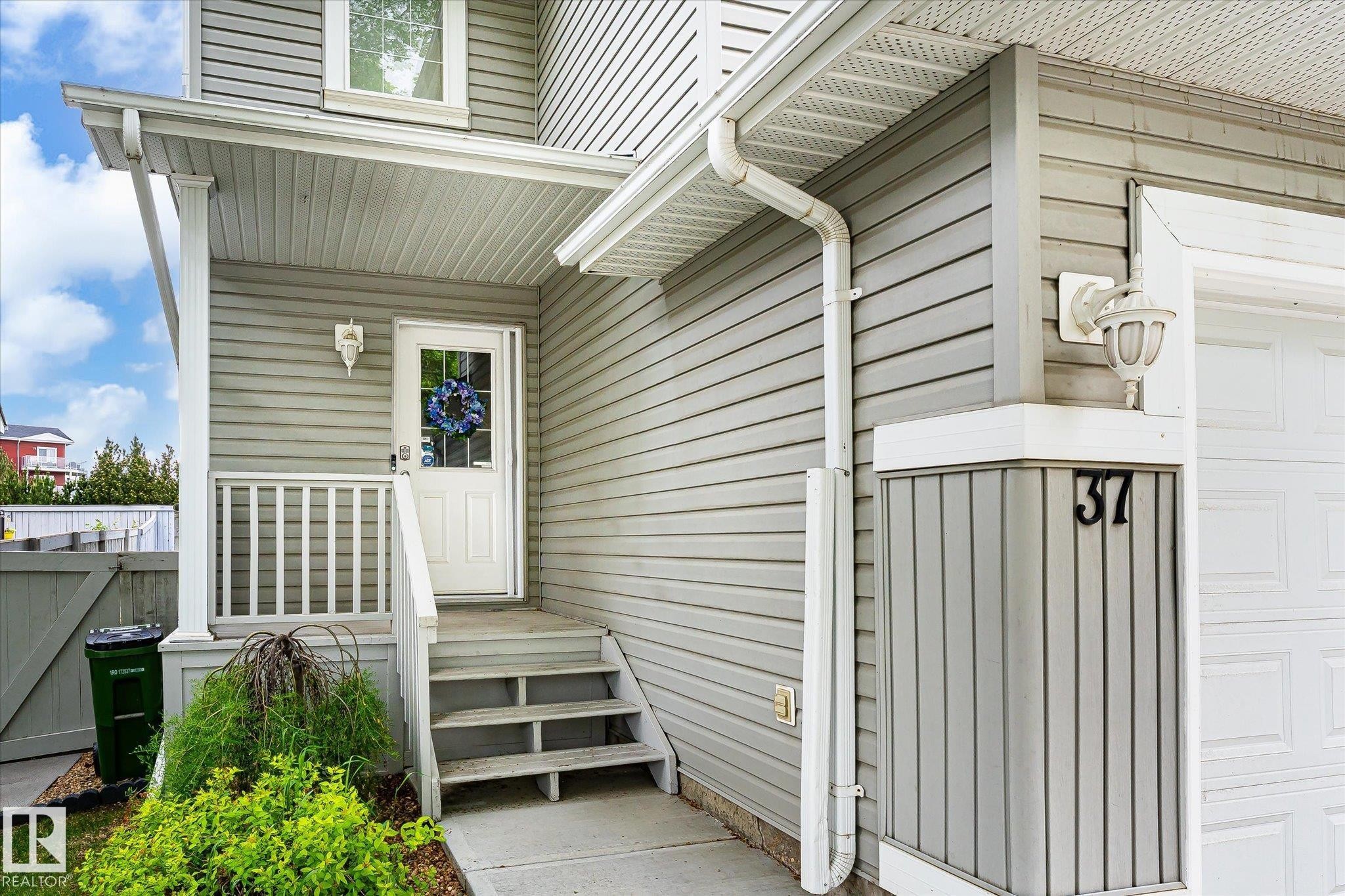 Front entrance featuring a white door with a window, covered porch, and white railing - #37 4020 21 St Nw, Edmonton, AB - Outdoor With Exterior