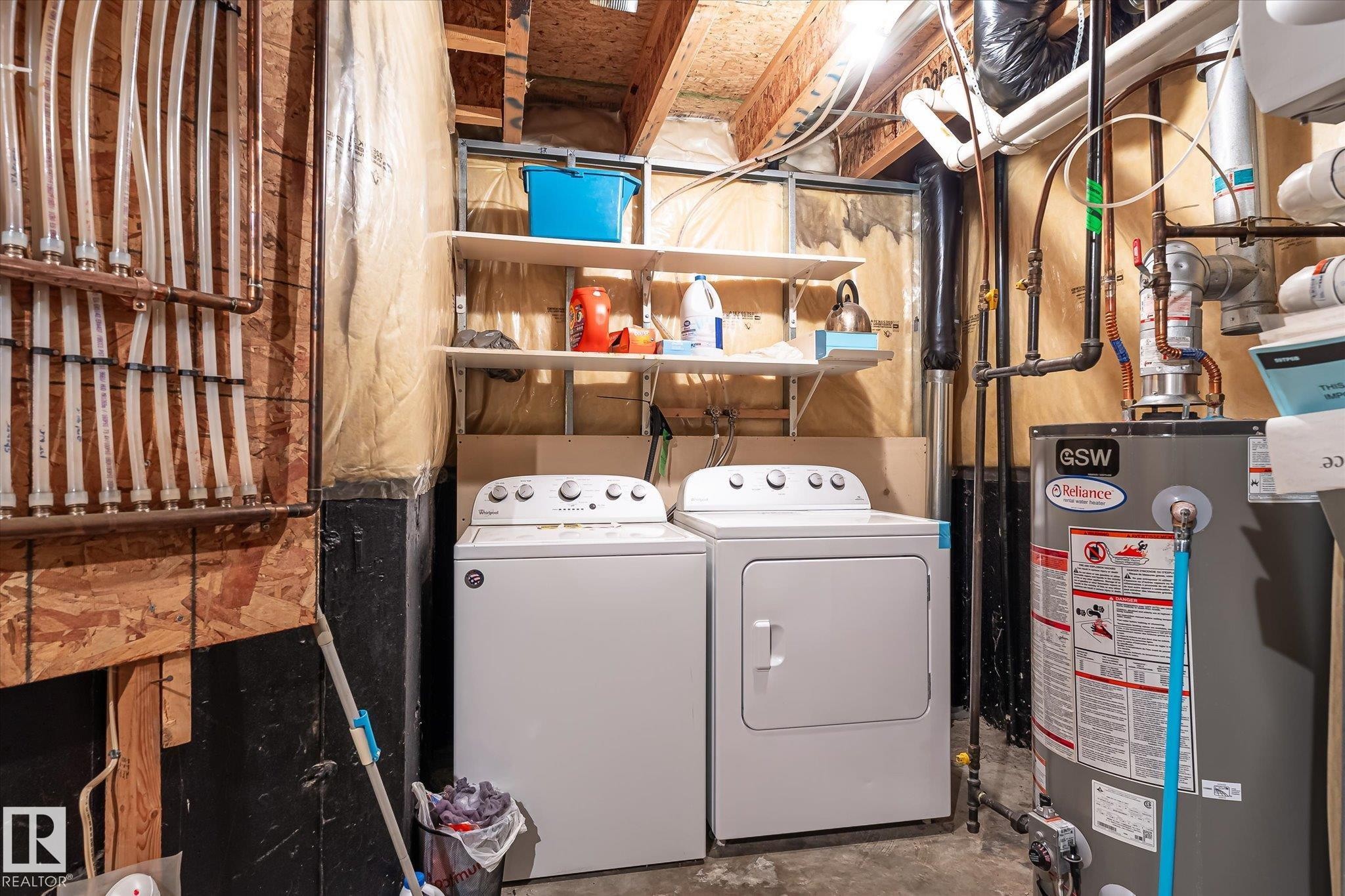 Dedicated utility area featuring a washer and dryer, water heater, and exposed overhead plumbing - #37 4020 21 St Nw, Edmonton, AB - Indoor Photo Showing Laundry Room