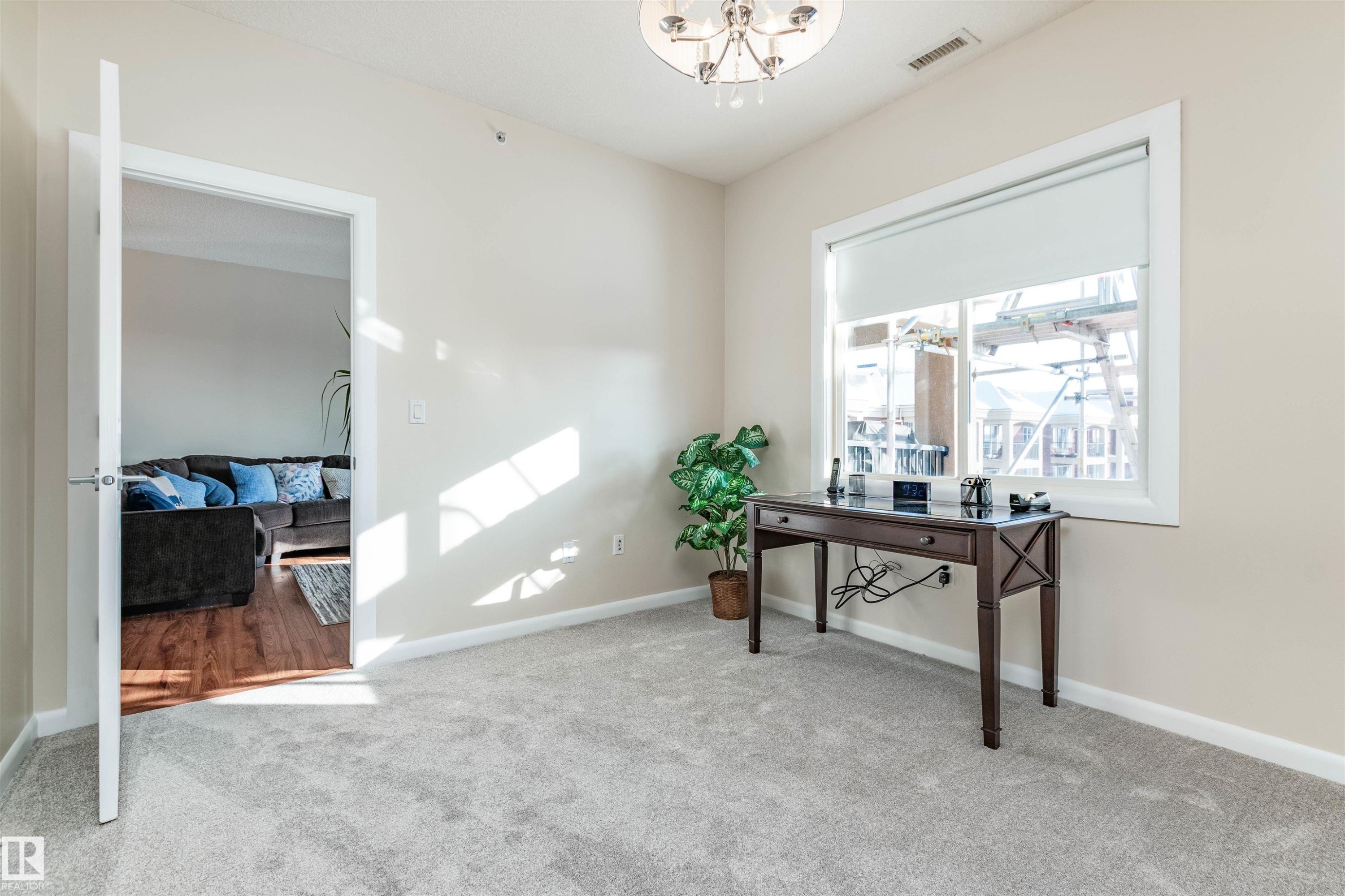 Carpeted room with a large window featuring a roller shade and white trim - 439 300 Palisades Way, Sherwood Park, AB - Indoor Photo Showing Other Room