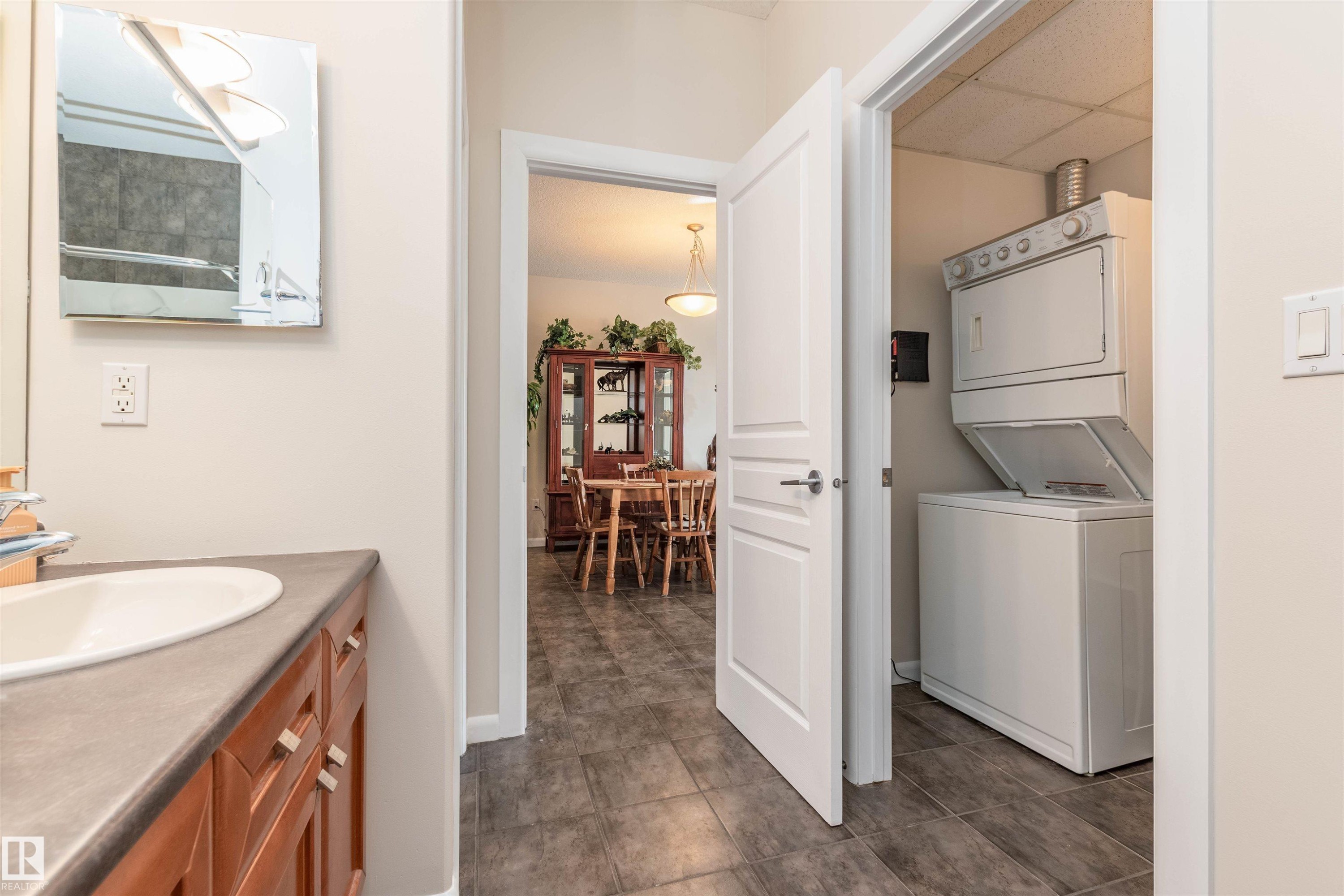 Integrated laundry closet featuring a stacked washer and dryer - 439 300 Palisades Way, Sherwood Park, AB - Indoor Photo Showing Laundry Room