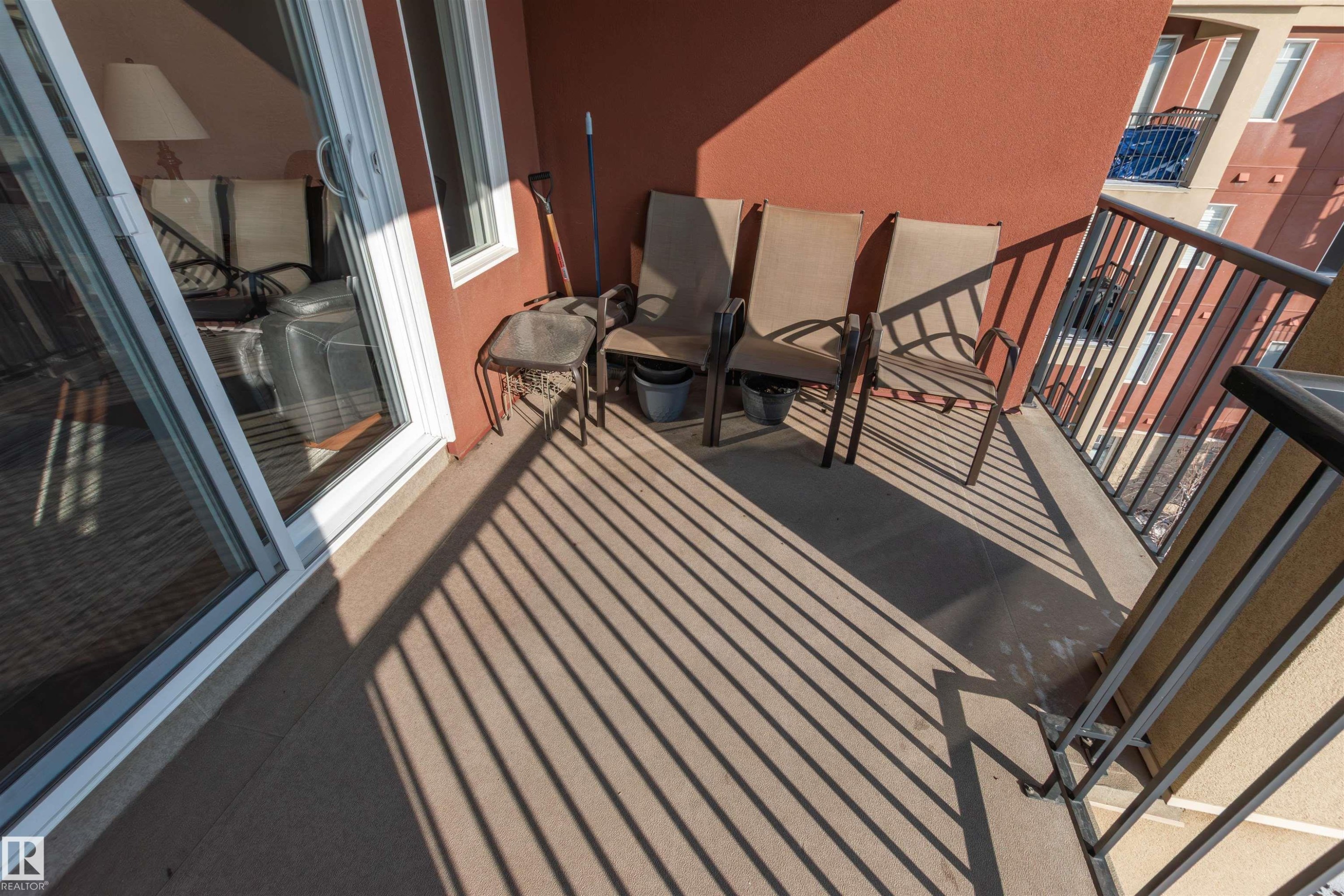 Private balcony featuring a concrete surface, red exterior wall, and black metal railing - 439 300 Palisades Way, Sherwood Park, AB - Outdoor With Balcony With Exterior