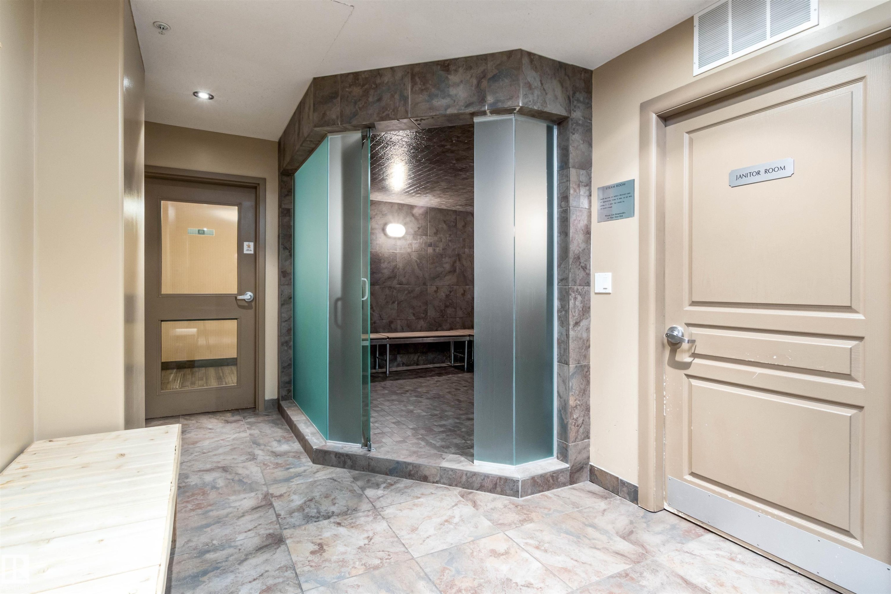 Sauna room featuring frosted glass entrance, tile flooring, built-in wooden bench seating, and wall-mounted lighting - 439 300 Palisades Way, Sherwood Park, AB - Indoor Photo Showing Other Room