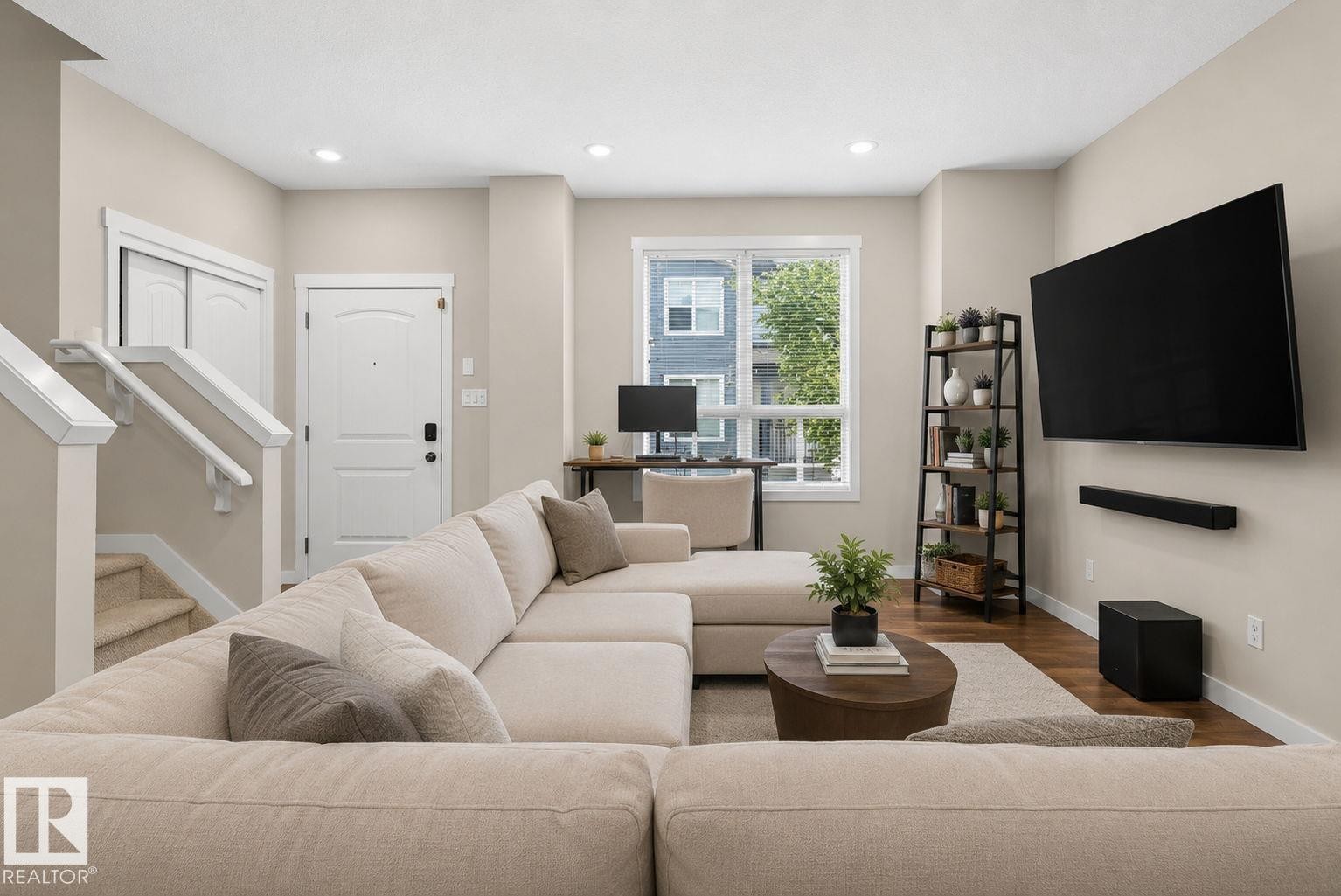 Open-concept living area with wood-finish flooring, recessed lighting, and a neutral color palette - 30 6075 Schonsee Way, Edmonton, AB
