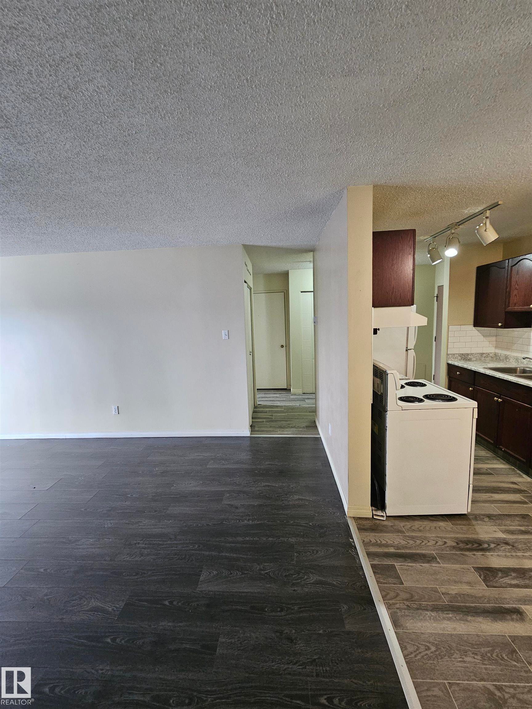 Contemporary wood-finish flooring complements light-toned walls - 401 10615 110 Street, Edmonton, AB