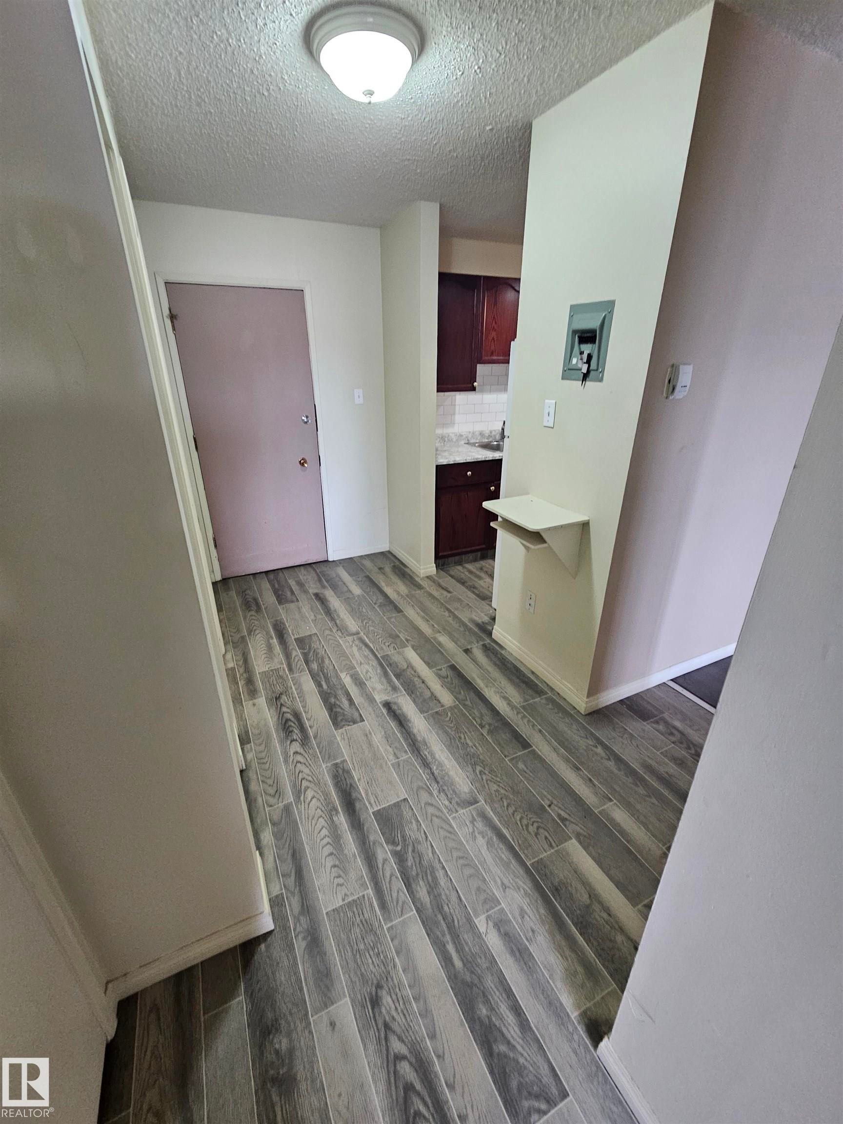 Wide plank wood-finish flooring extending throughout the space - 401 10615 110 Street, Edmonton, AB