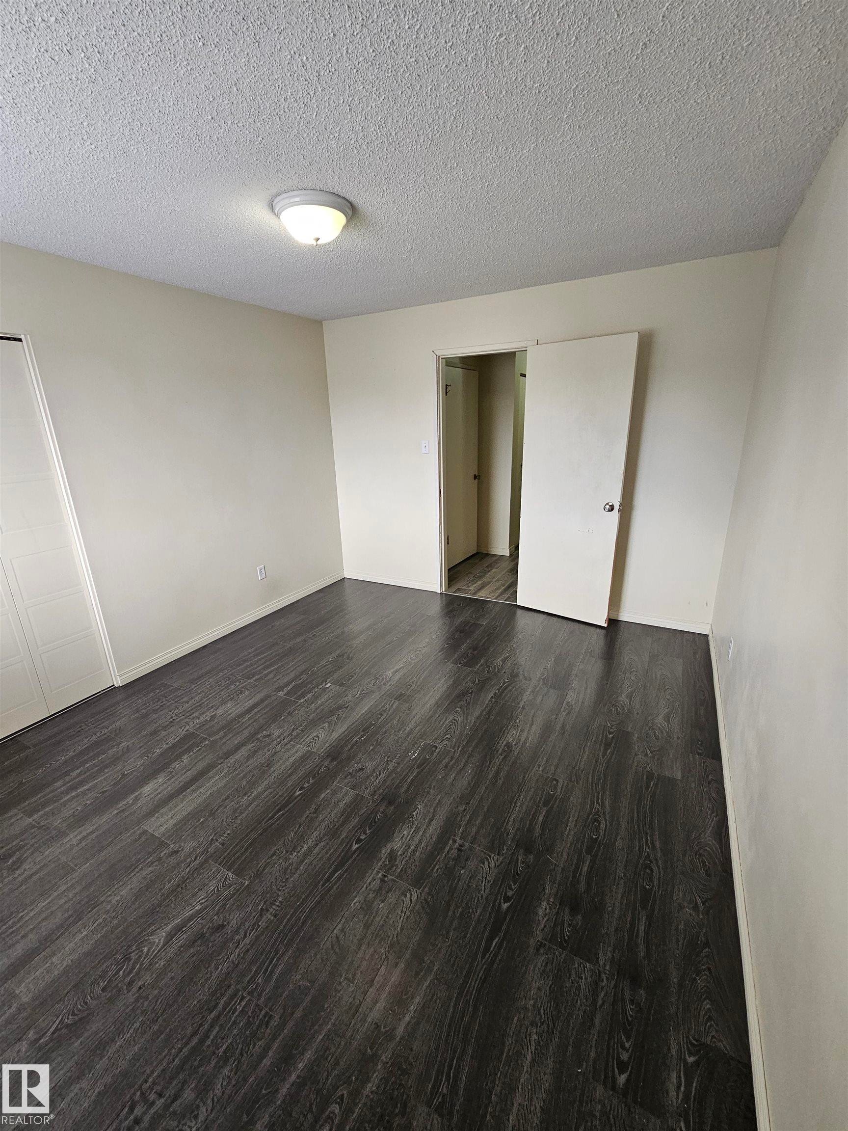 Spacious room with dark wood-finish flooring - 401 10615 110 Street, Edmonton, AB