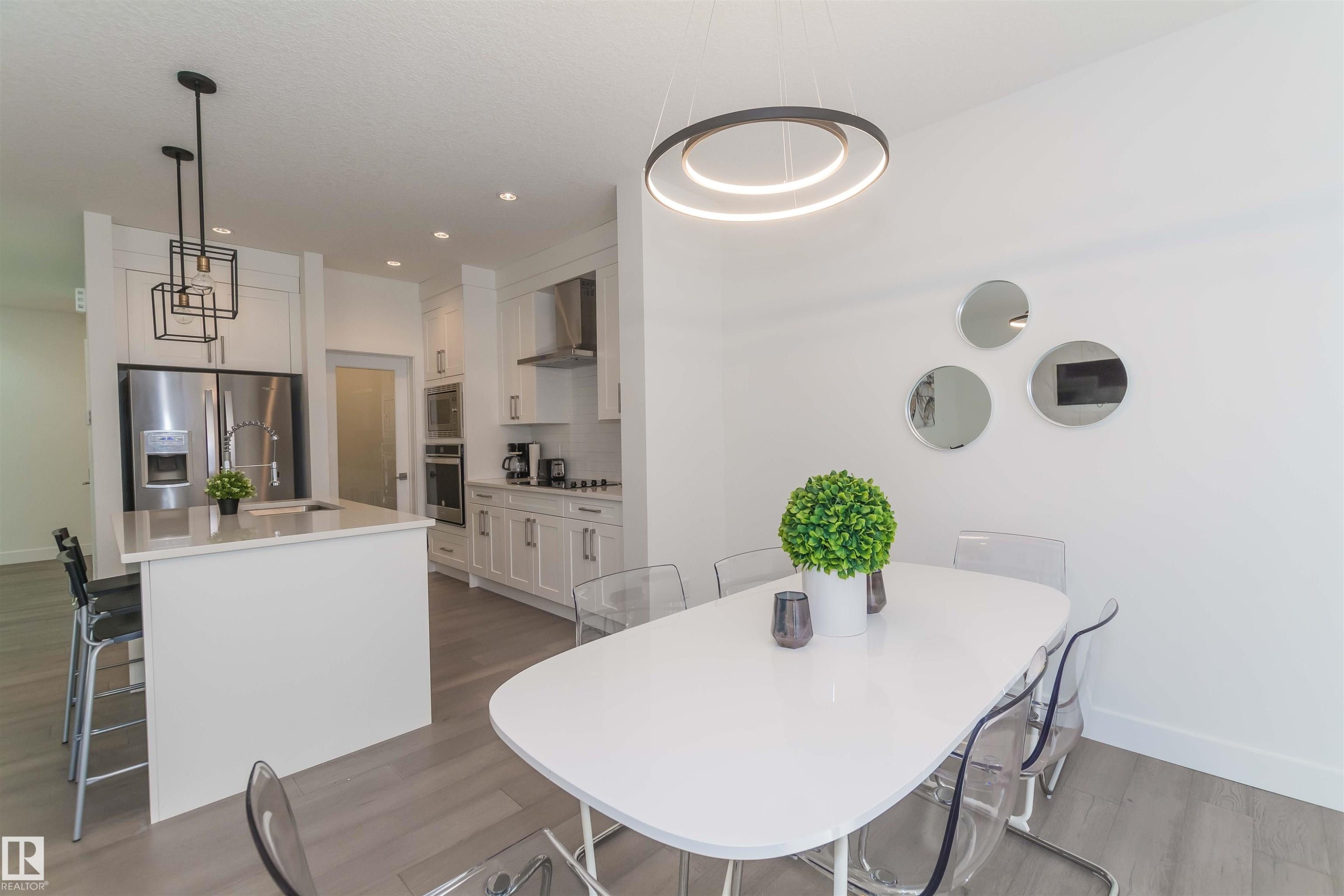 Modern kitchen and dining area featuring light wood-finish flooring - 15168 16 Street Nw, Edmonton, AB