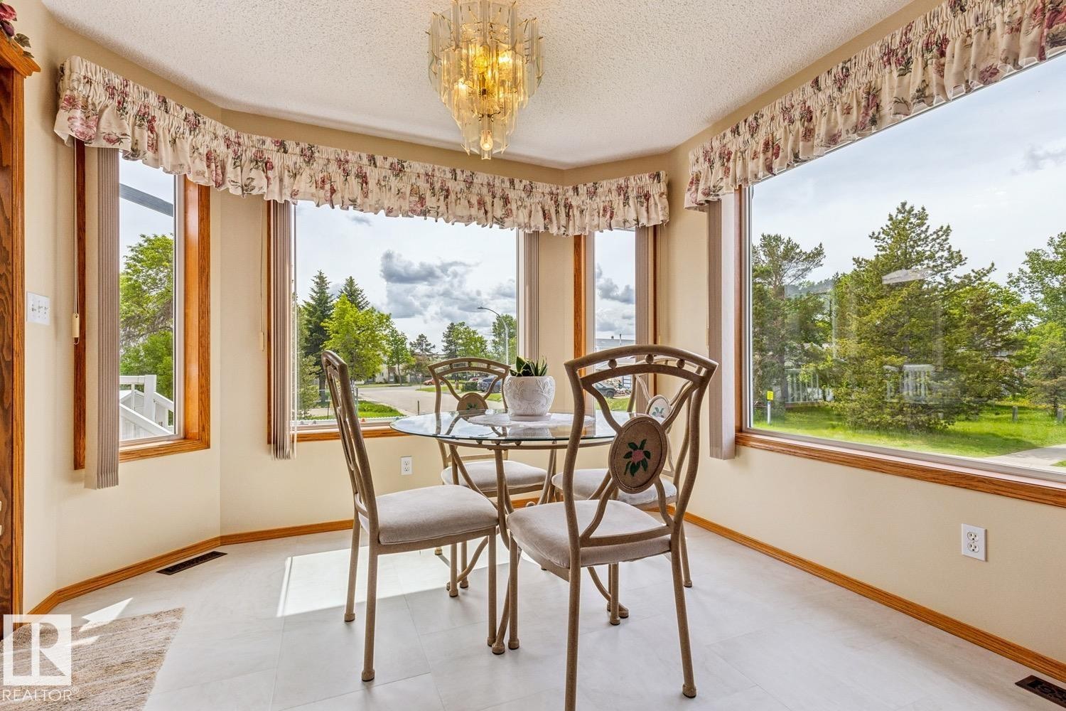 Bay window area featuring light-toned walls, wood-finish trim, a textured ceiling - 5131 152A Avenue, Edmonton, AB