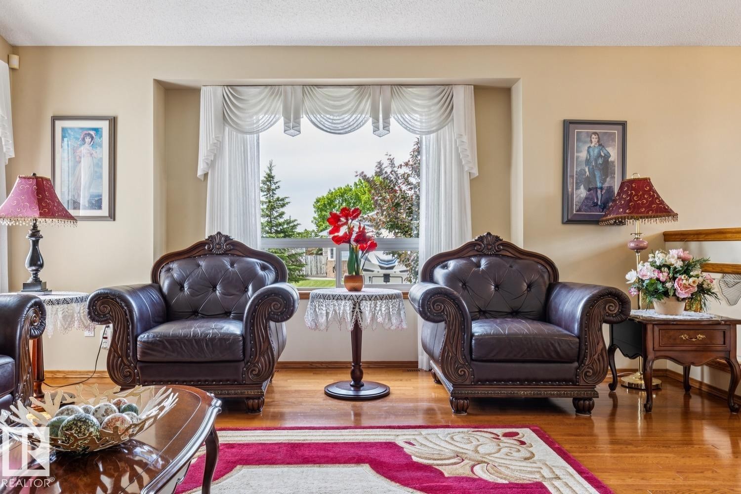 Hardwood flooring extends through this living area, featuring a large bay window and neutral wall tones - 5131 152A Avenue, Edmonton, AB