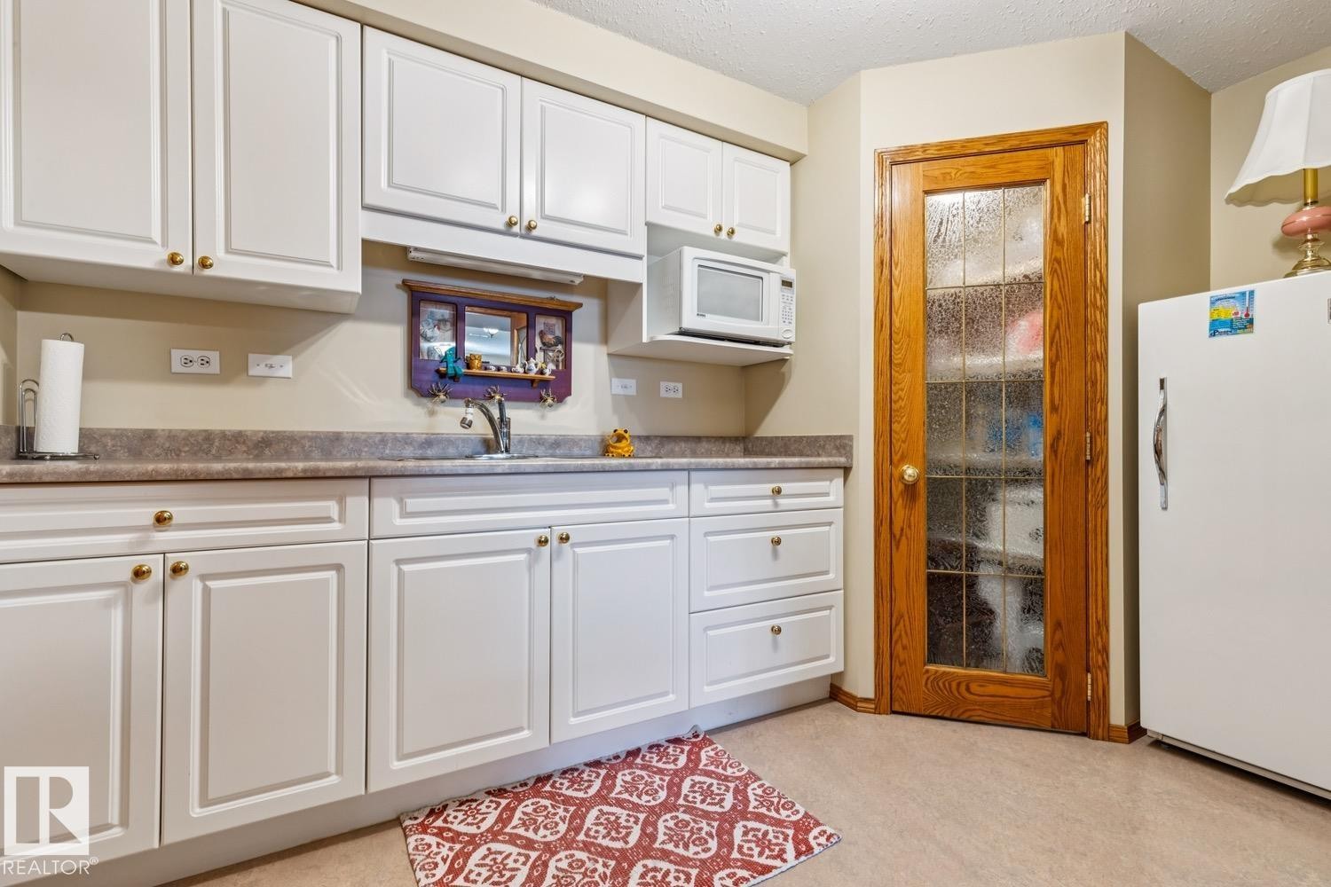 Kitchen in the basement features pantry, sink and ample cabinets - 5131 152A Avenue, Edmonton, AB
