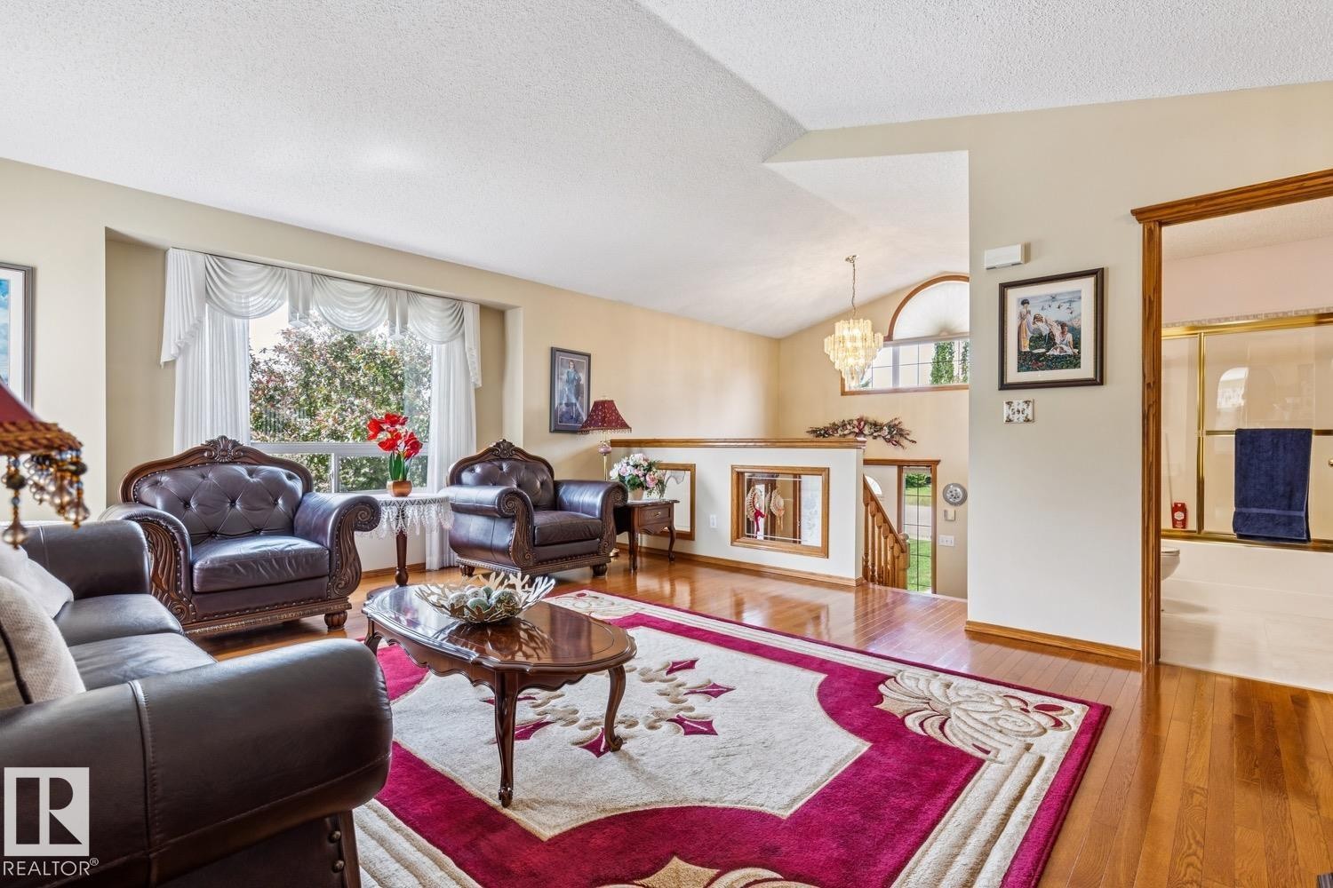 Spacious living room featuring wood-finish flooring and a large bay window - 5131 152A Avenue, Edmonton, AB