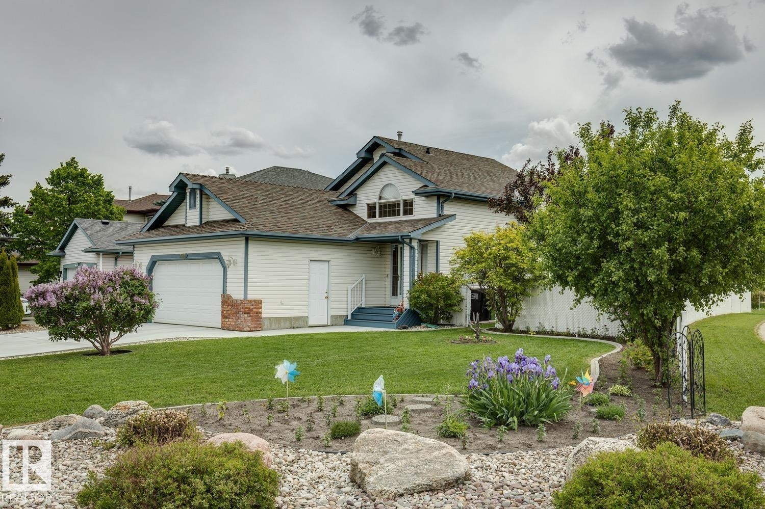 Contemporary residence featuring white siding with blue trim accents and a two-car garage - 5131 152A Avenue, Edmonton, AB