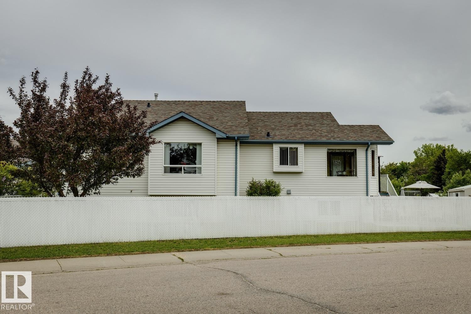 White vinyl siding exterior with a brown shingle roof and blue trim - 5131 152A Avenue, Edmonton, AB