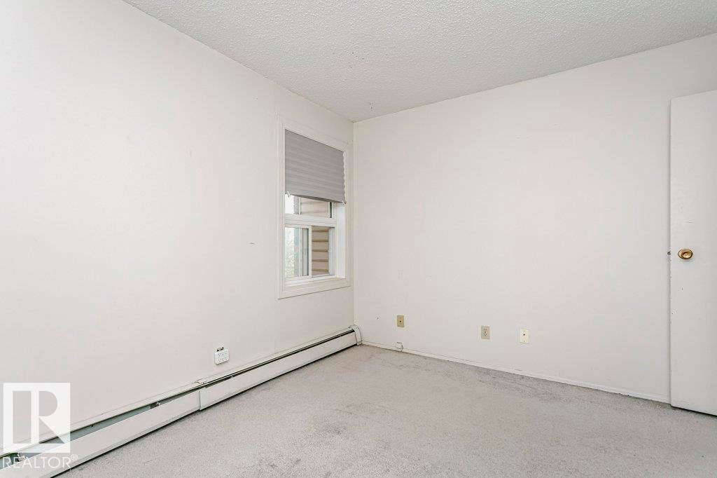 Room featuring light gray carpeting, a window with horizontal blinds, and a white interior door - 71 11255 31 Avenue, Edmonton, AB - Indoor Photo Showing Other Room