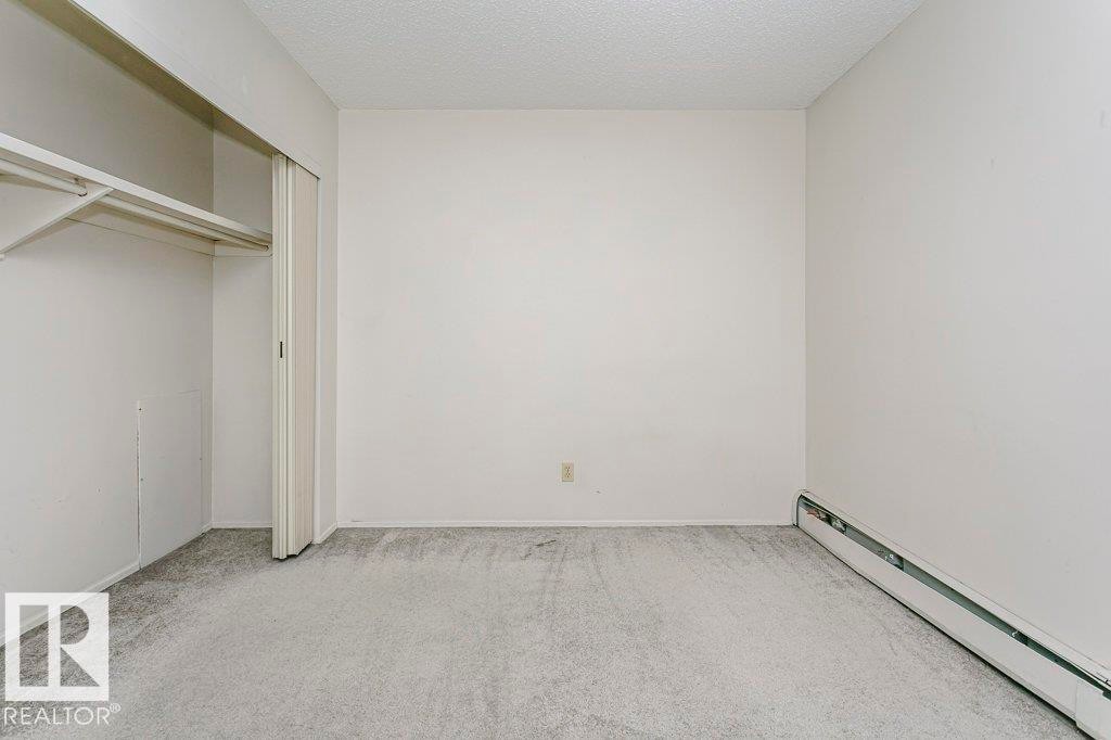 Spacious room featuring light grey carpeting, white walls, and a white popcorn ceiling - 71 11255 31 Avenue, Edmonton, AB - Indoor Photo Showing Other Room