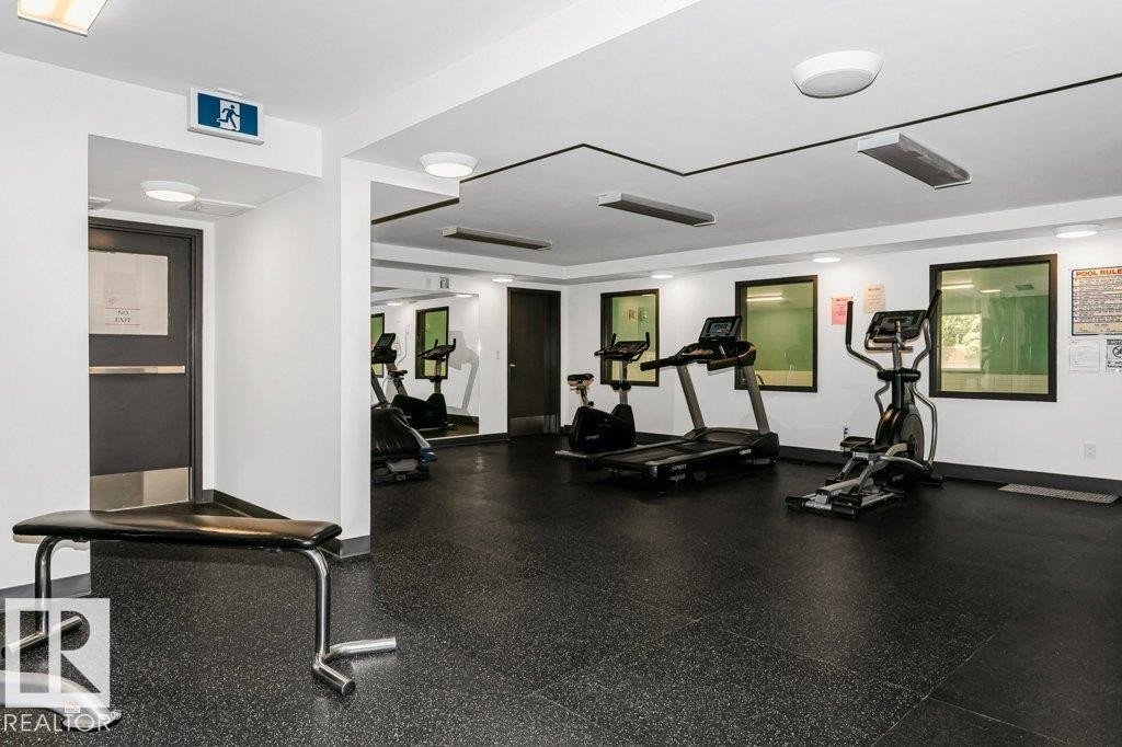 Fitness room with black rubber flooring, recessed lighting, and mirrored wall accents - 71 11255 31 Avenue, Edmonton, AB - Indoor Photo Showing Gym Room