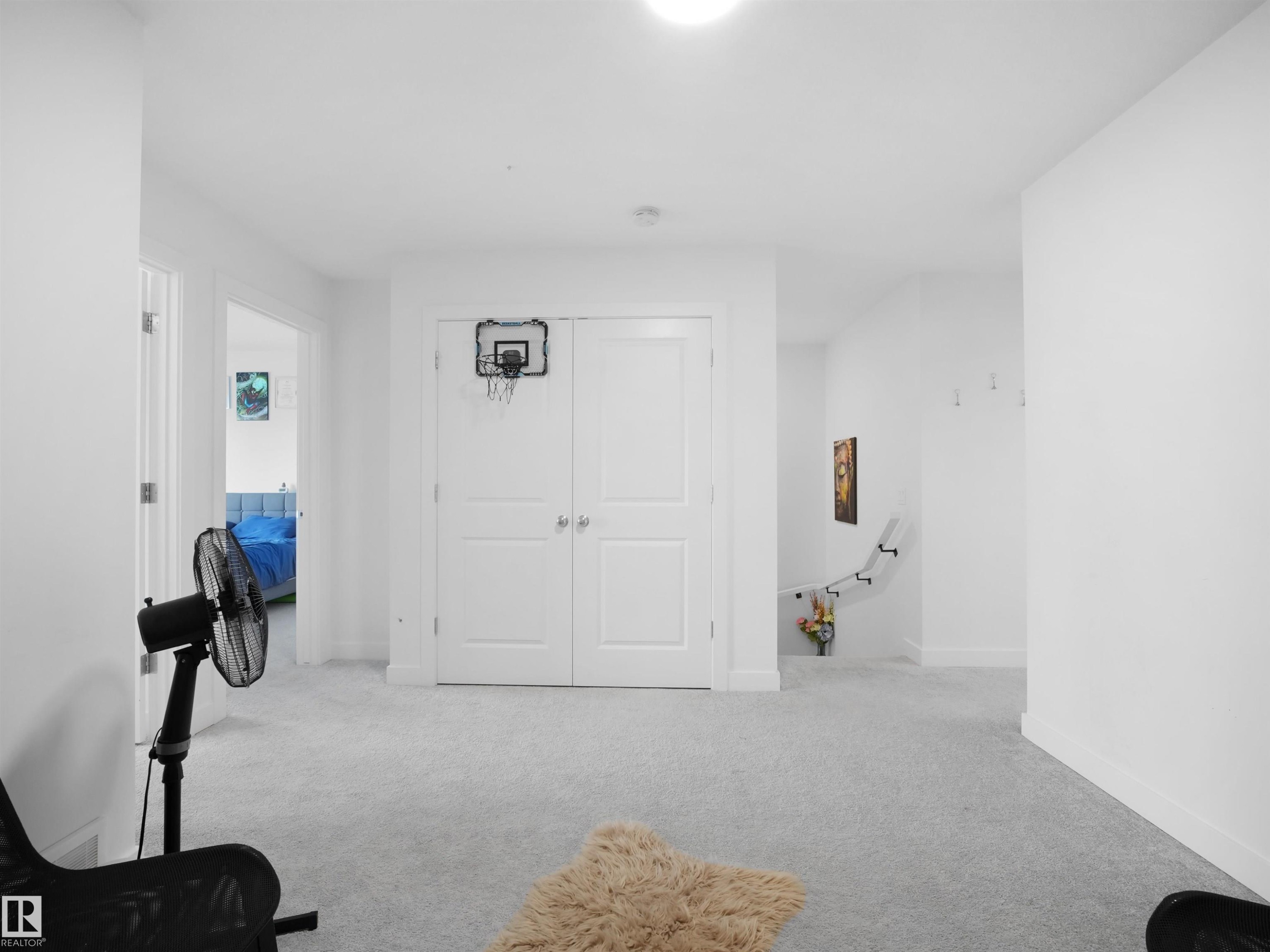 Open hallway with light gray carpeting, white walls, and white trim - 19316 29 Avenue, Edmonton, AB