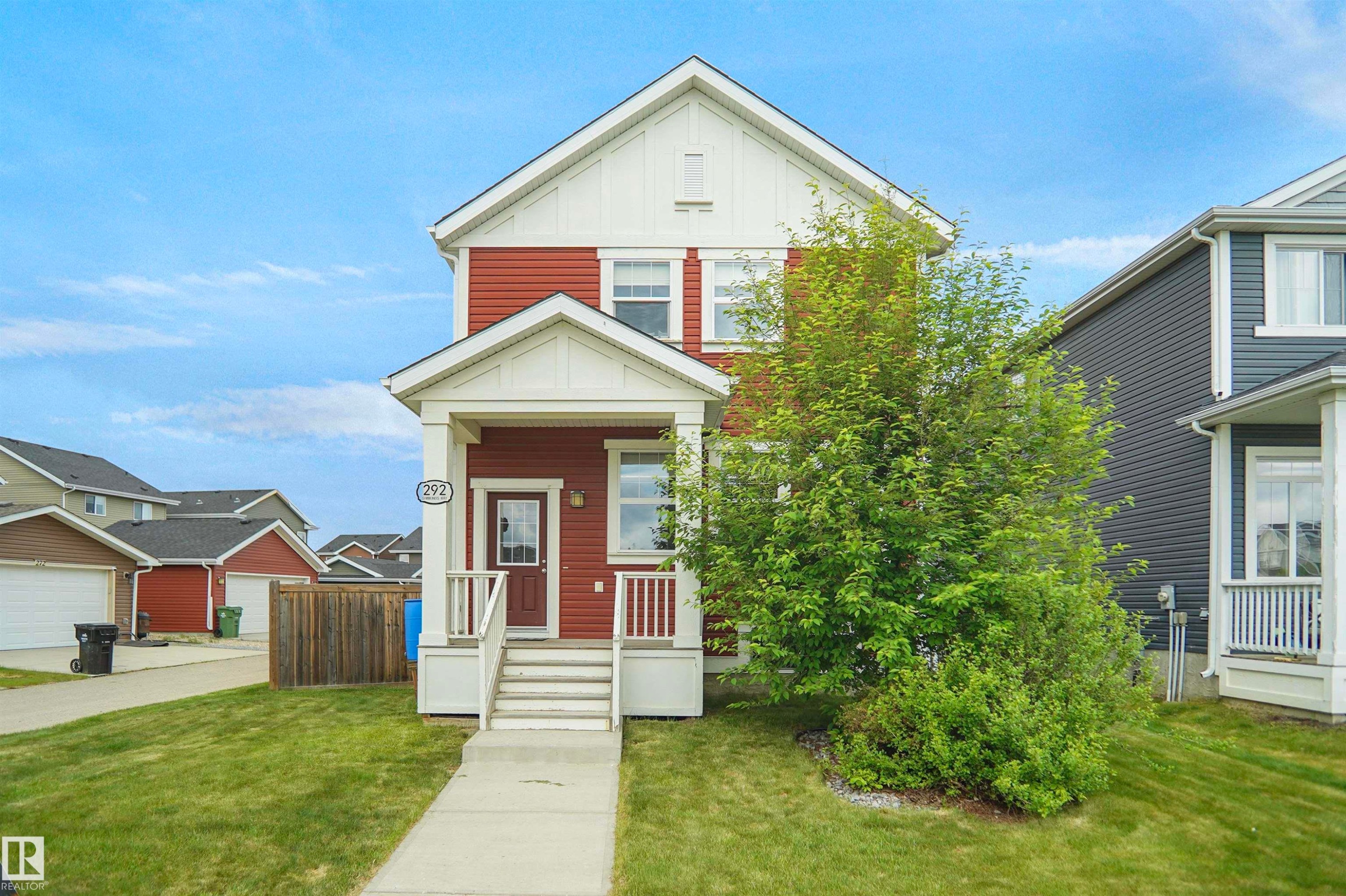 Two-story residence featuring red siding and white trim - 292 Simmonds Way, Leduc, AB