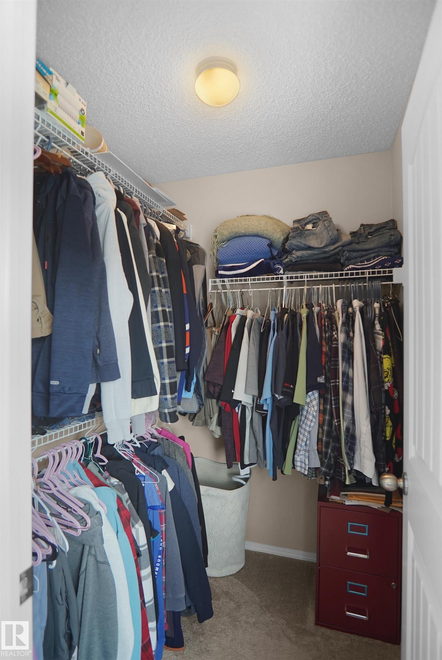 Walk-in closet with carpet flooring, wire shelving, and overhead lighting - 292 Simmonds Way, Leduc, AB