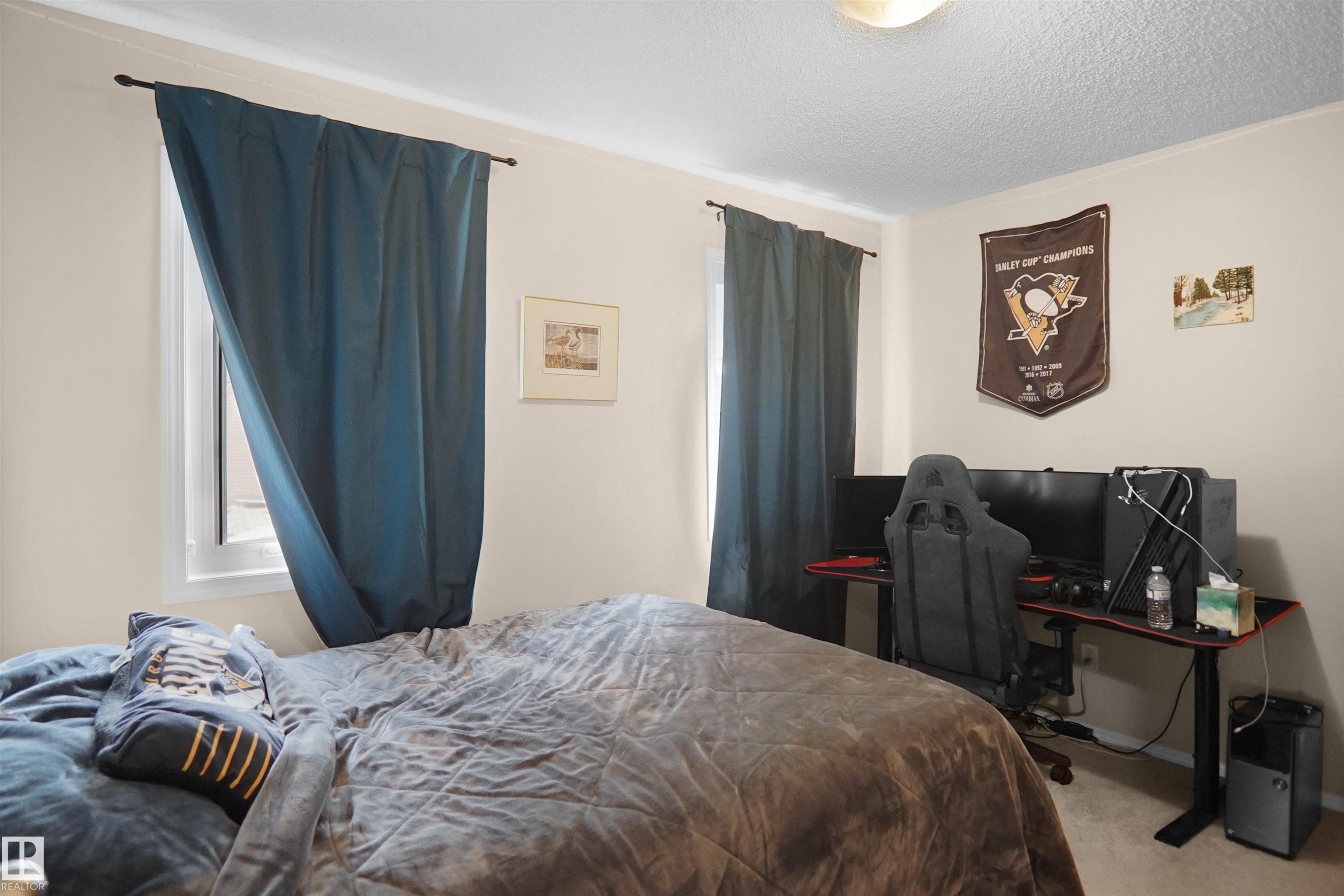 Neutral-toned walls complement the window with a dark blue curtain rod and drapery - 292 Simmonds Way, Leduc, AB