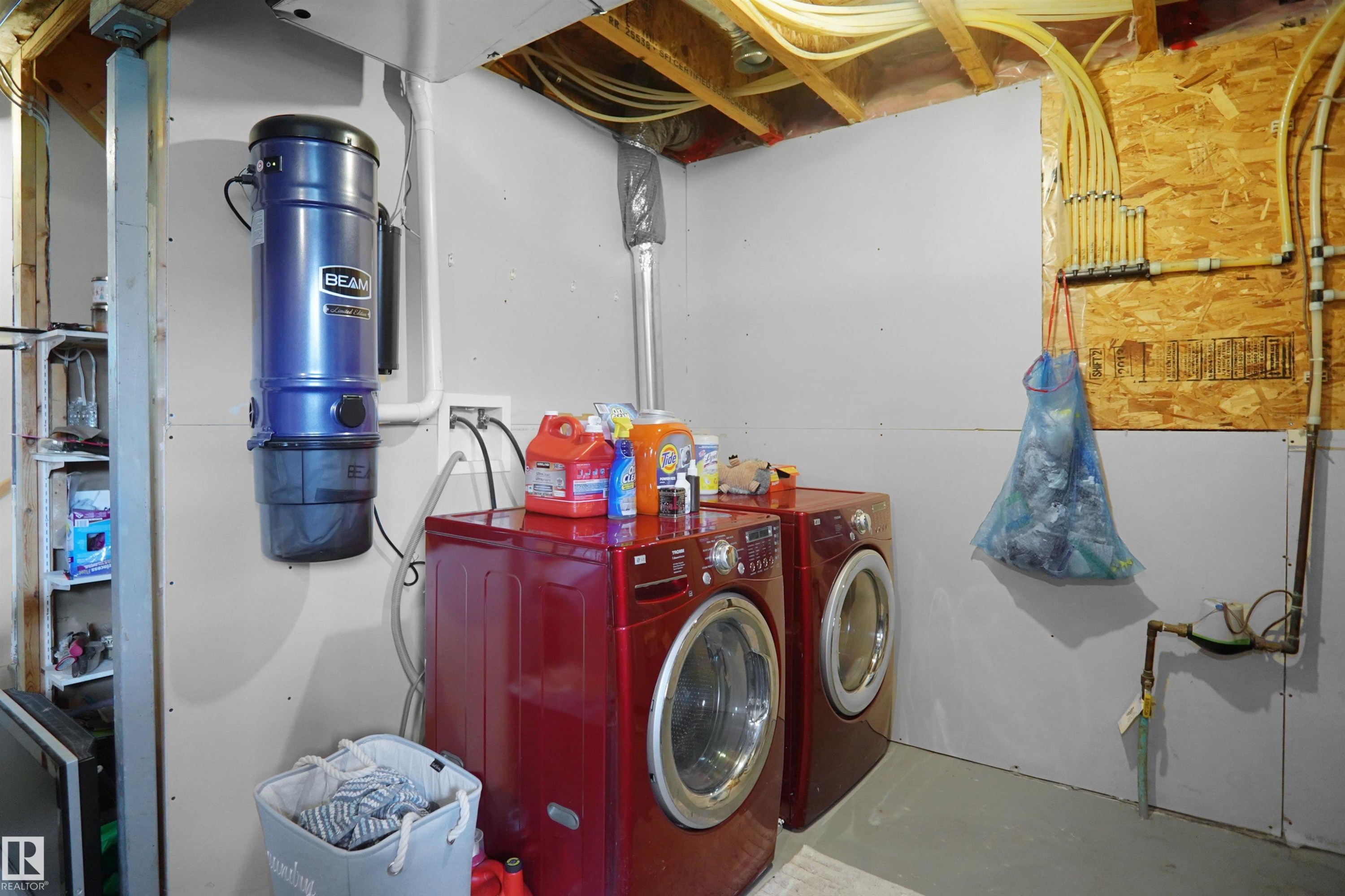 Utility space featuring a central vacuum system, exposed ceiling joists, and visible plumbing - 292 Simmonds Way, Leduc, AB