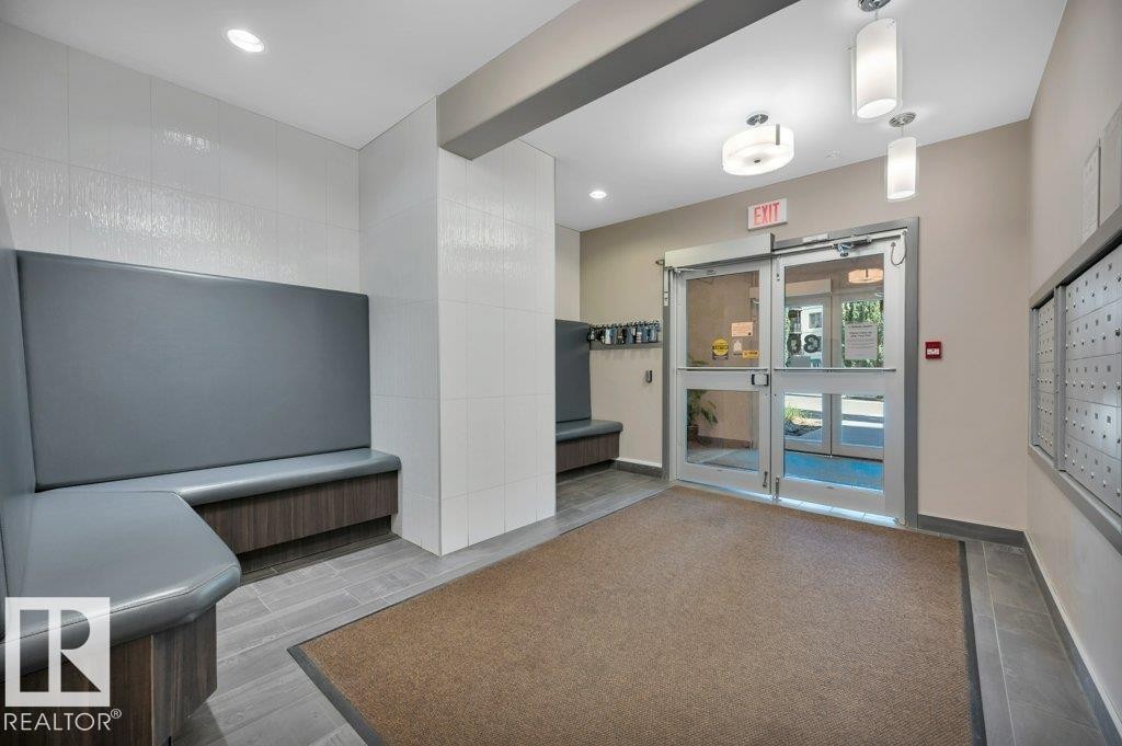 Entryway featuring double glass doors, recessed lighting, and built-in seating with wood-finish base - 140 308 Ambleside Link Link, Edmonton, AB