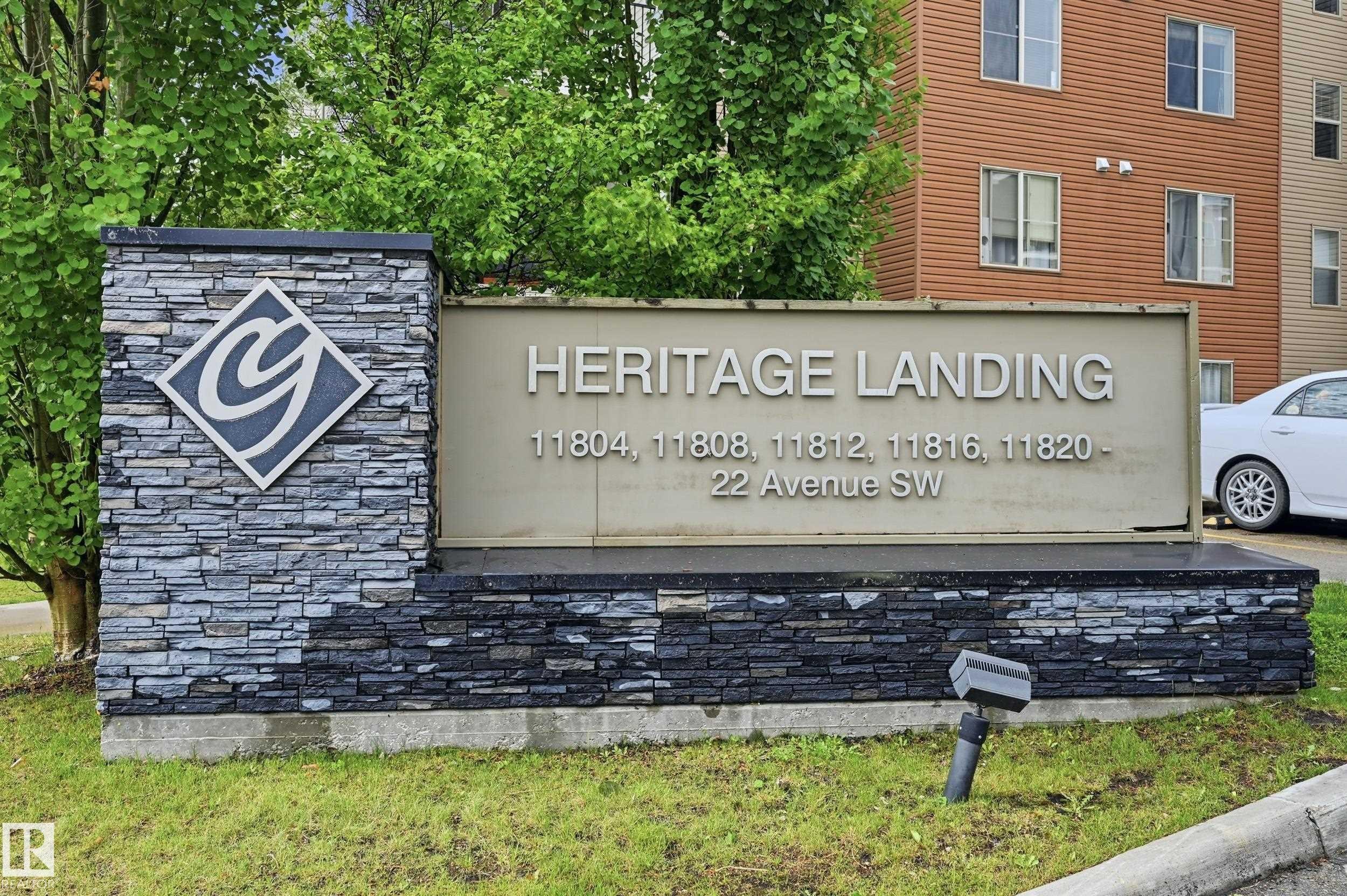 Heritage Landing monument sign featuring stacked stone veneer, a diamond-shaped logo, and street number identification - 304 11804 22 Avenue, Edmonton, AB