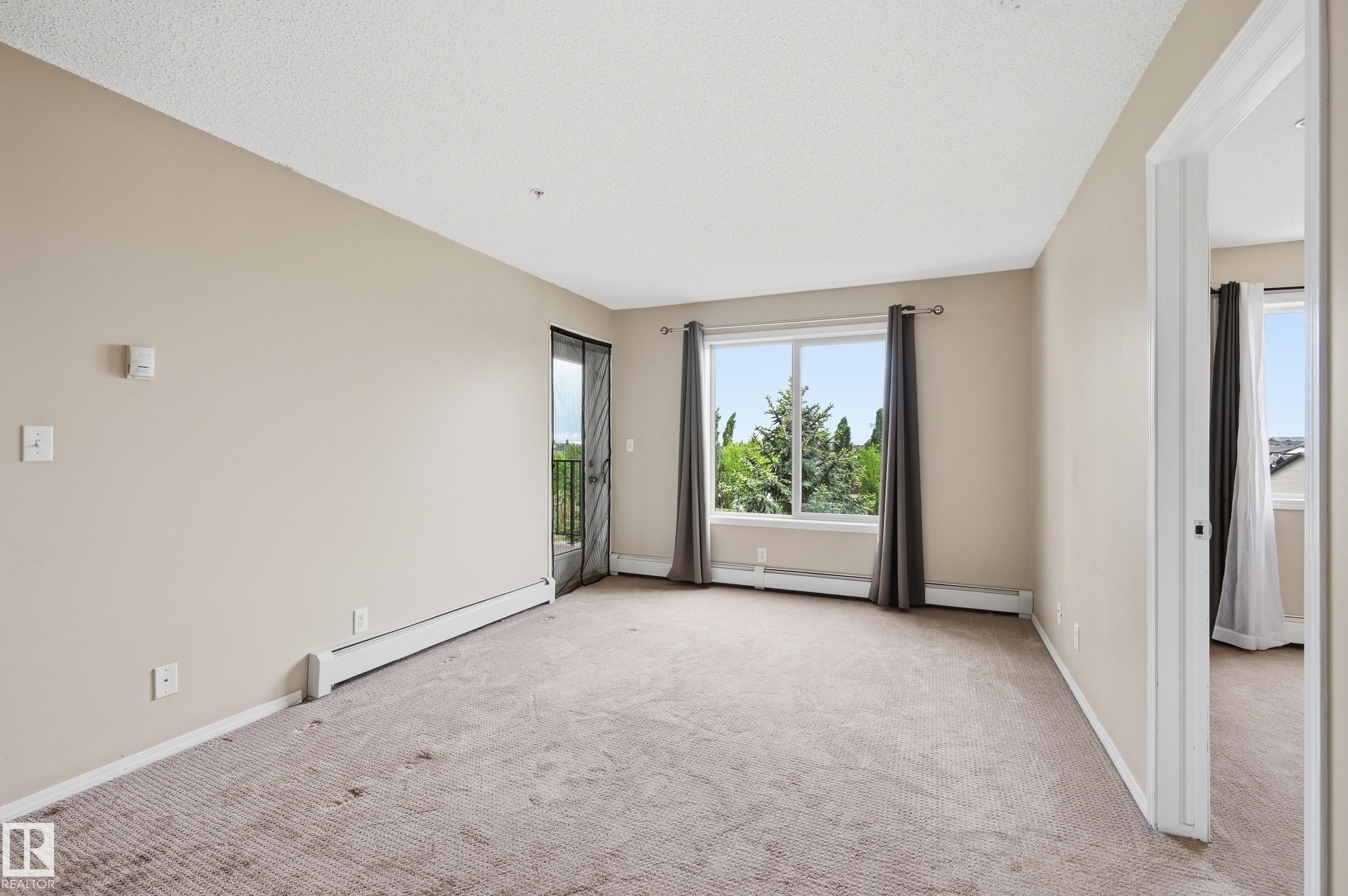 Spacious room featuring neutral carpeting and light-toned walls - 304 11804 22 Avenue, Edmonton, AB