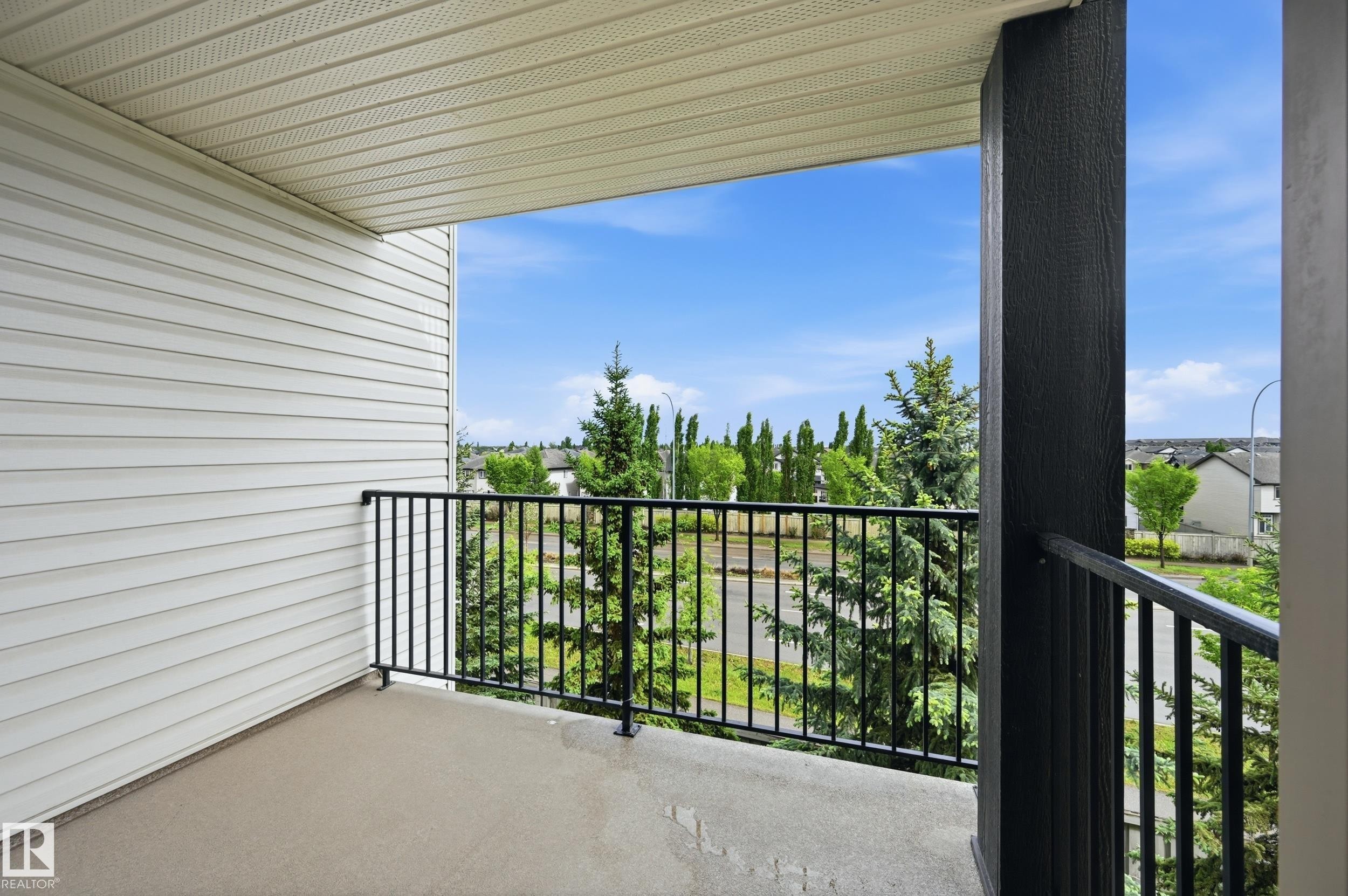 Exterior balcony featuring a concrete surface and black metal railings - 304 11804 22 Avenue, Edmonton, AB