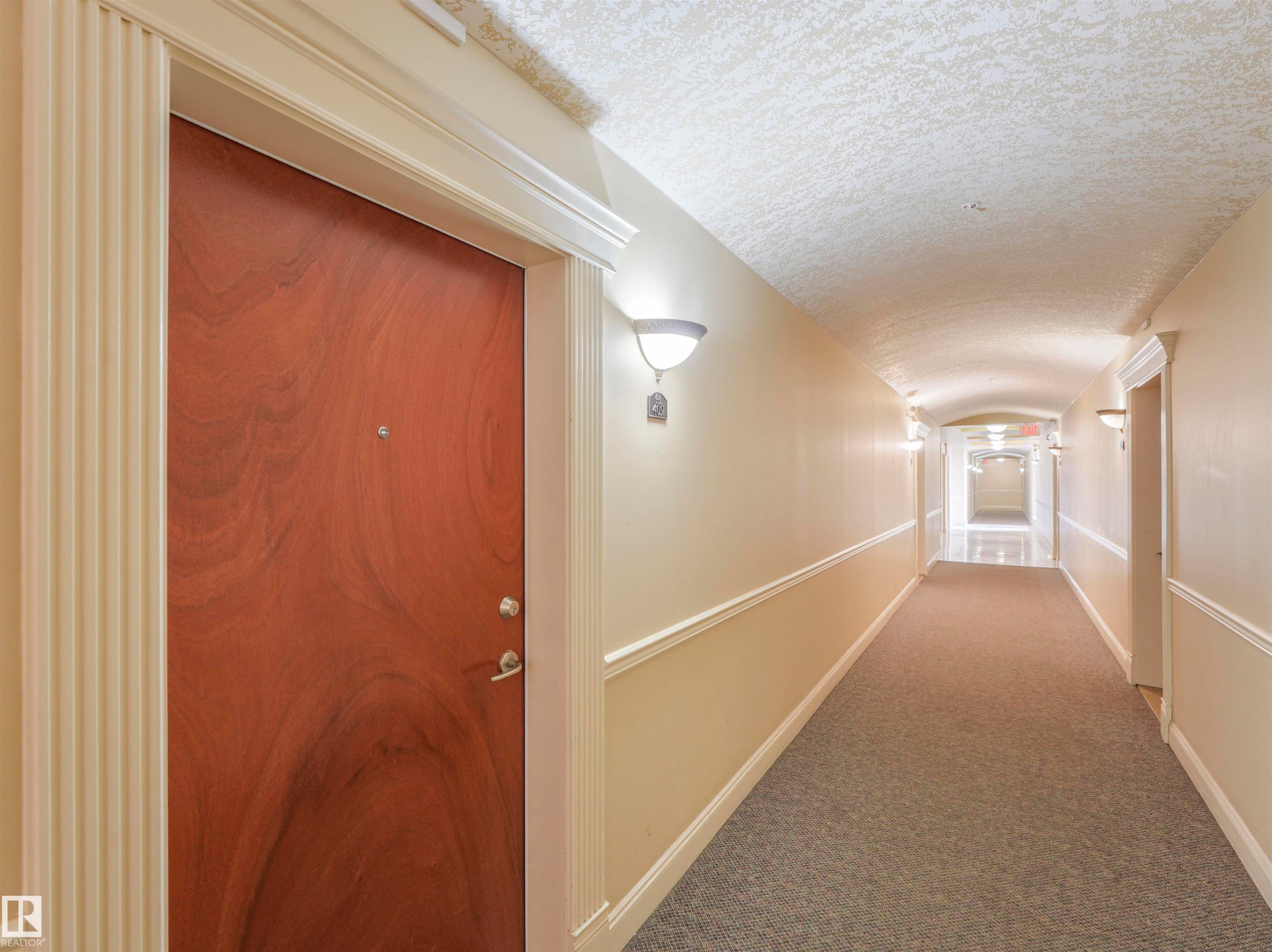 Entry door with fluted casing and detailed crown molding - #409 10333 112 St Nw, Edmonton, AB - Indoor Photo Showing Other Room