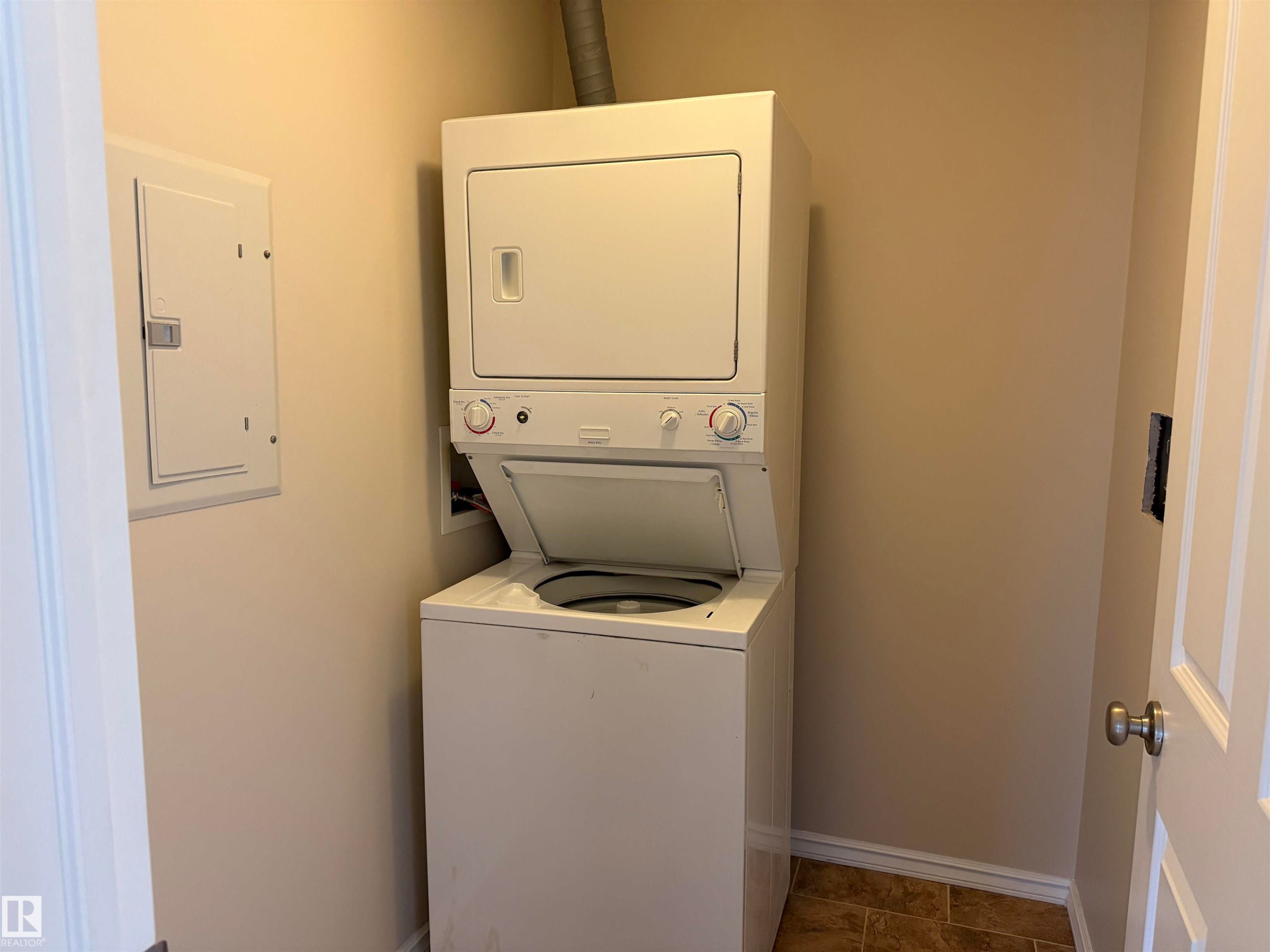 Dedicated laundry area featuring a stackable washer and dryer unit - 118 7801 Golf Course Road, Stony Plain, AB