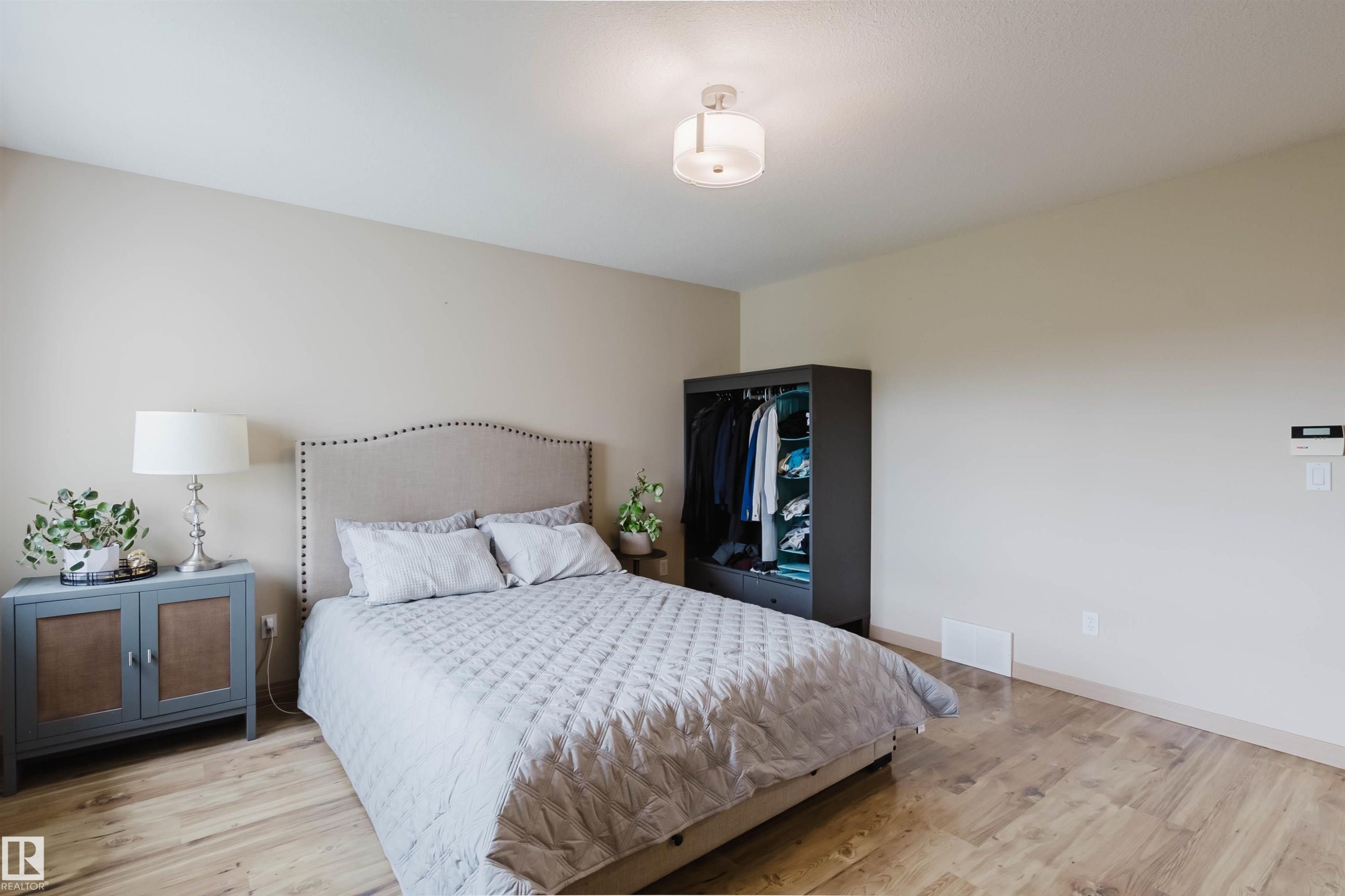 Bedroom featuring warm neutral wall tones and wood-finish flooring - 2236 Garnett Crest, Edmonton, AB