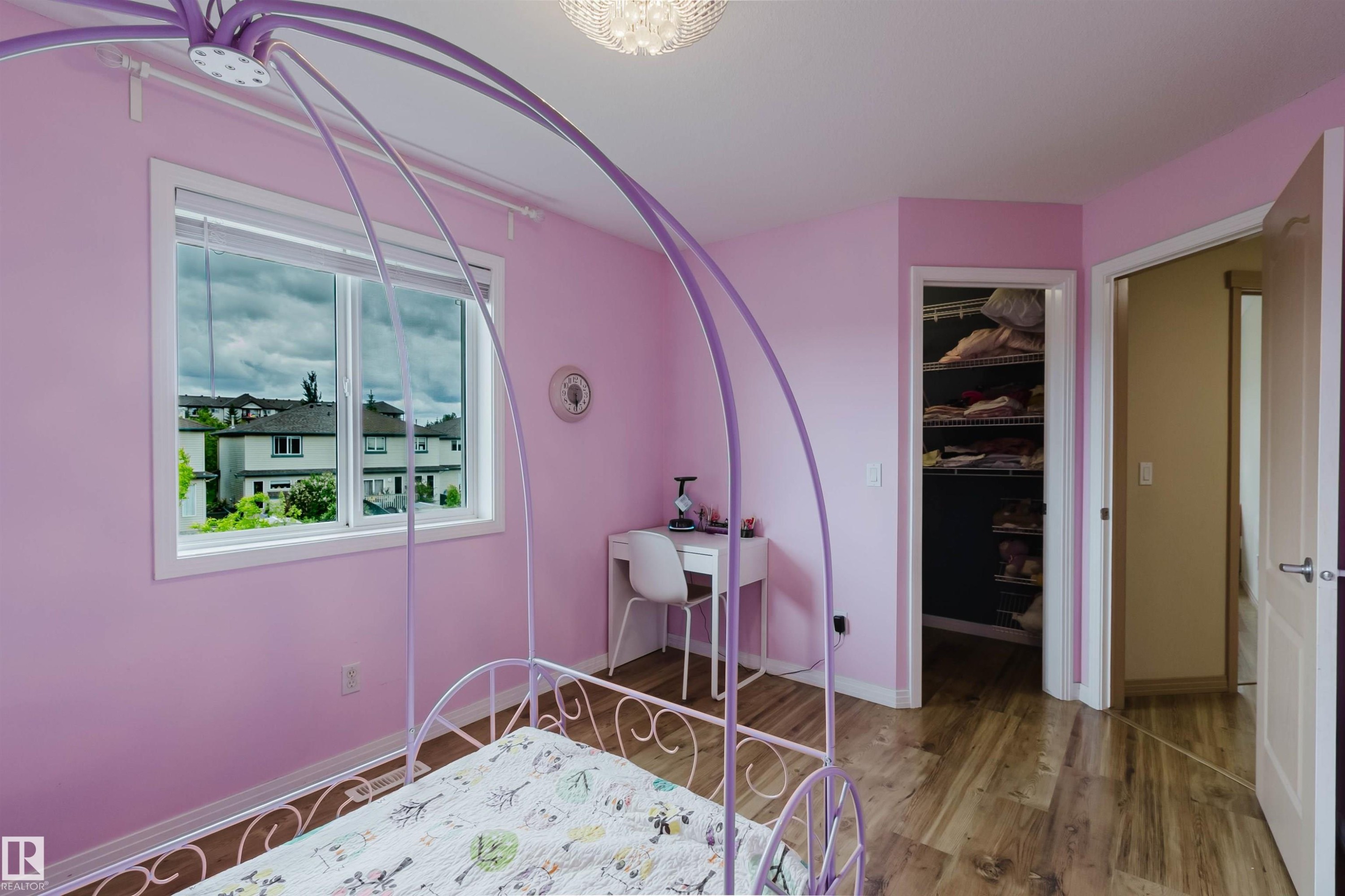 Room featuring wood-finish flooring, a double window, an open closet with shelving, and a modern ceiling light fixture - 2236 Garnett Crest, Edmonton, AB