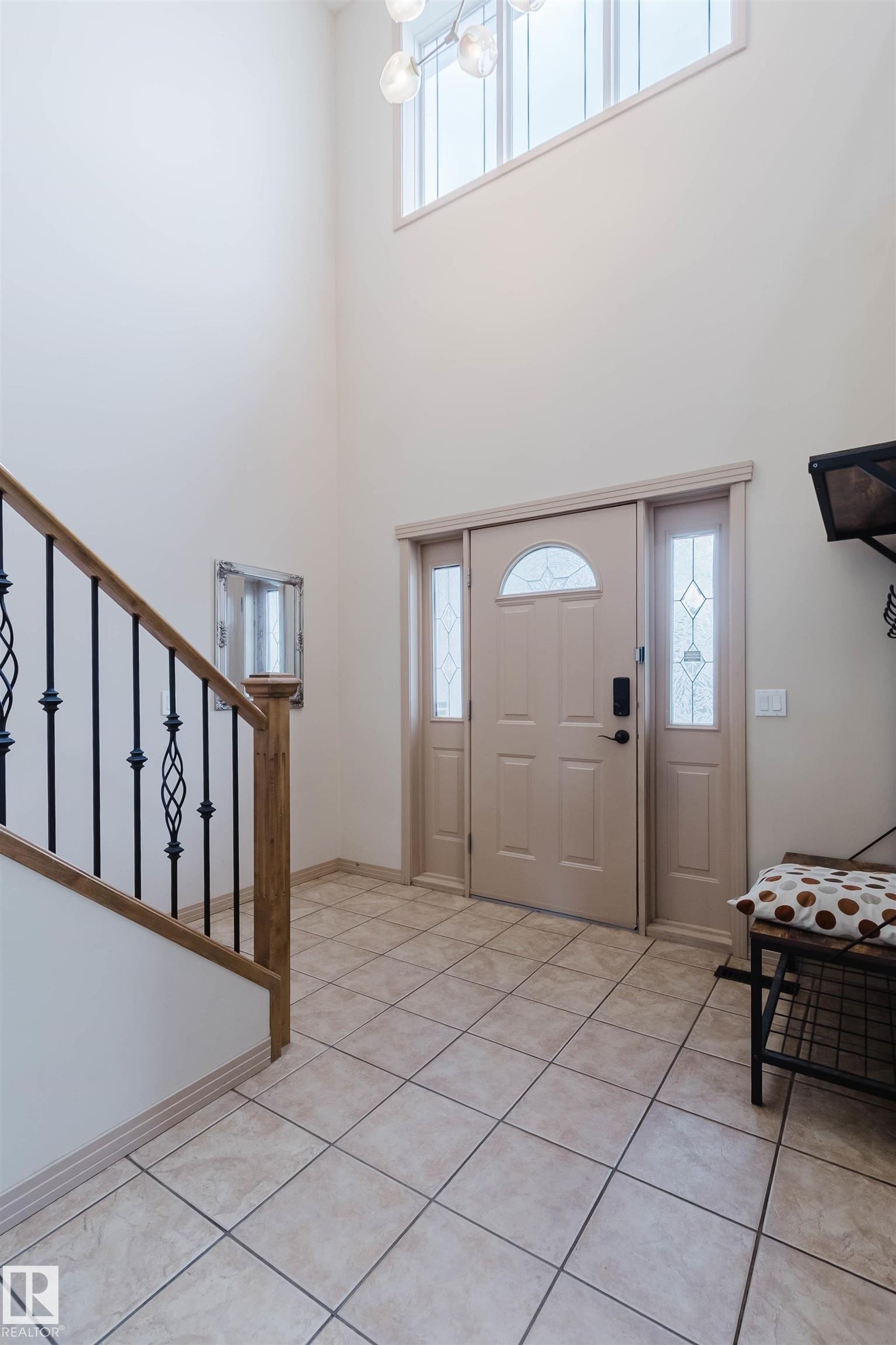 Two-story foyer with a decorative chandelier, transom window, and tiled flooring - 2236 Garnett Crest, Edmonton, AB