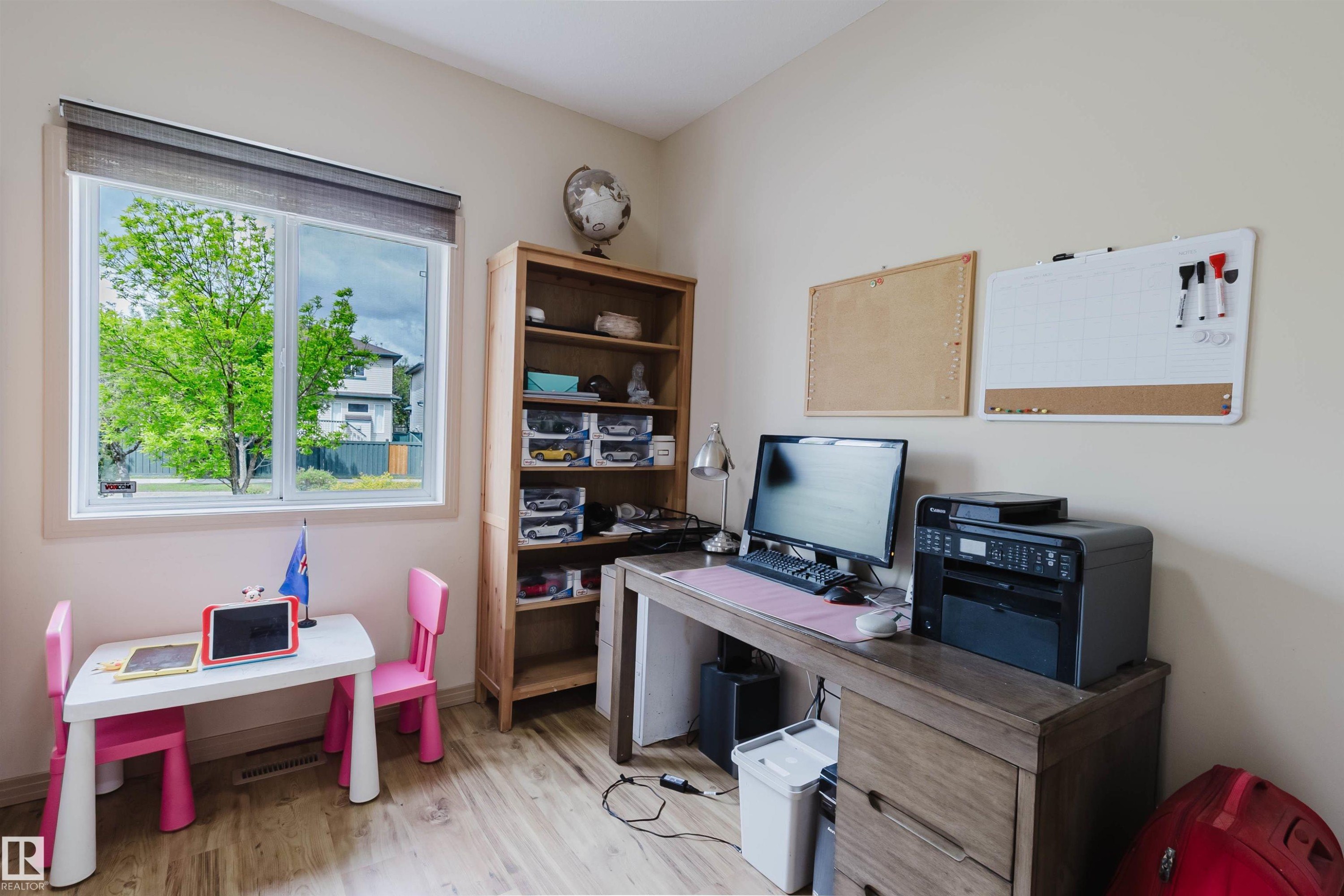Bright room featuring wood-finish flooring and a large window with roller shades - 2236 Garnett Crest, Edmonton, AB