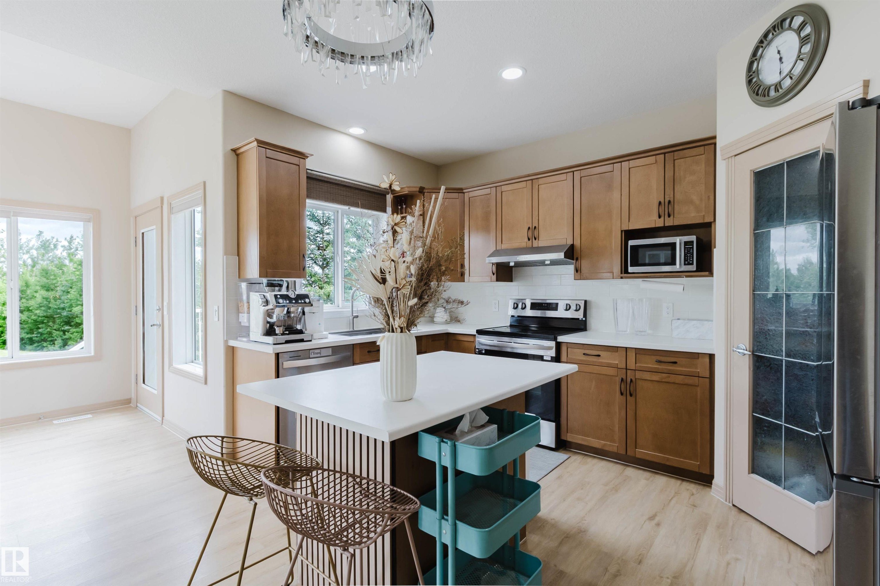 Light wood-finish flooring complements the warm-toned cabinetry in this kitchen - 2236 Garnett Crest, Edmonton, AB