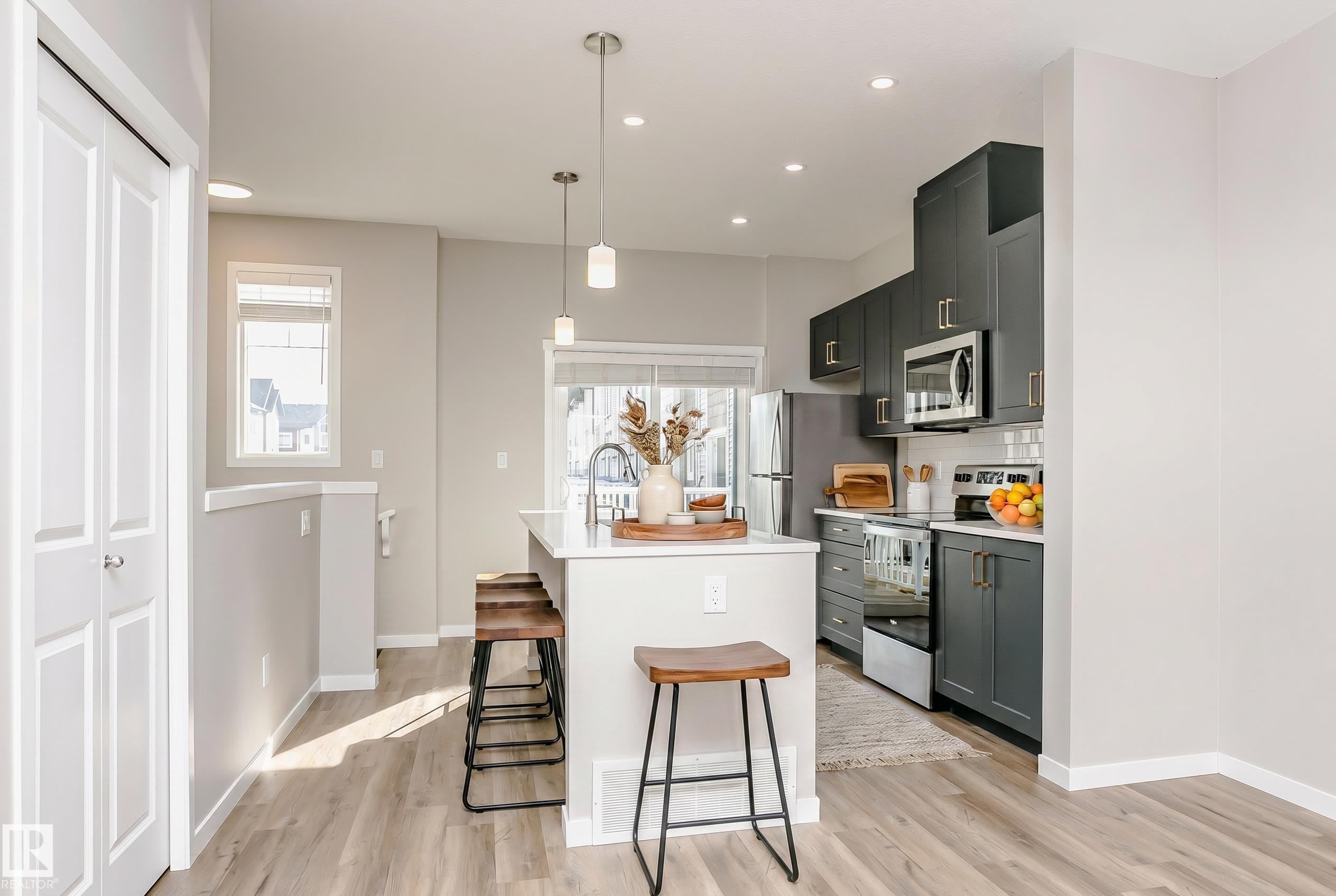 Kitchen featuring dark cabinetry, stainless steel appliances, white countertops, and a white subway tile backsplash - 320 Secord Boulevard, Edmonton, AB - Indoor Photo Showing Kitchen