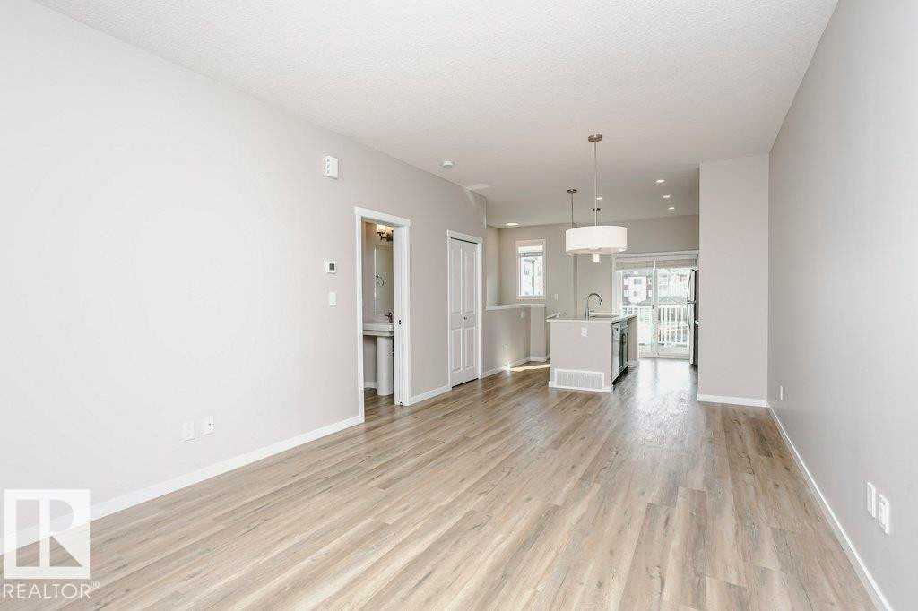 Open concept living area featuring light-toned flooring and neutral walls - 320 Secord Boulevard, Edmonton, AB - Indoor Photo Showing Other Room