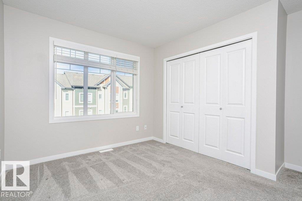 This room features light grey walls and grey carpet flooring - 320 Secord Boulevard, Edmonton, AB - Indoor Photo Showing Other Room