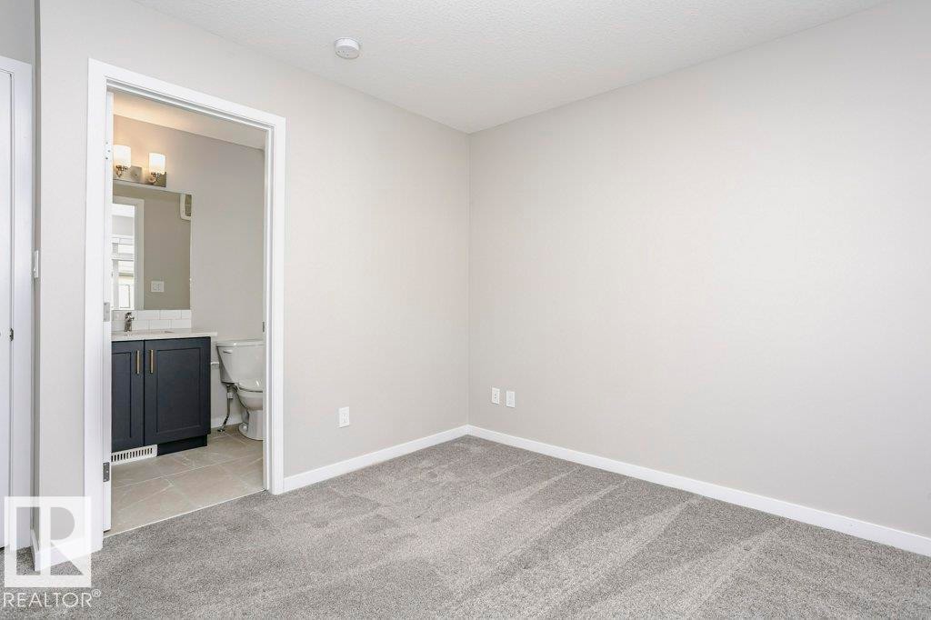 This room features light grey walls and grey carpet flooring - 320 Secord Boulevard, Edmonton, AB - Indoor Photo Showing Other Room