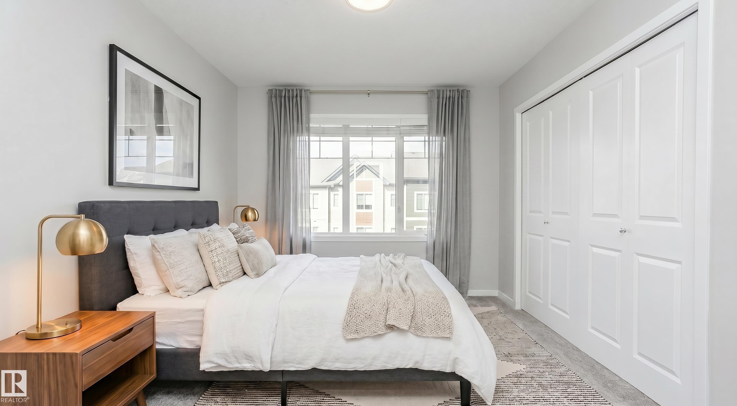 Bedroom featuring light gray walls, wood-finish flooring, a contemporary window with drapes, and white bi-fold closet doors - 320 Secord Boulevard, Edmonton, AB - Indoor Photo Showing Bedroom