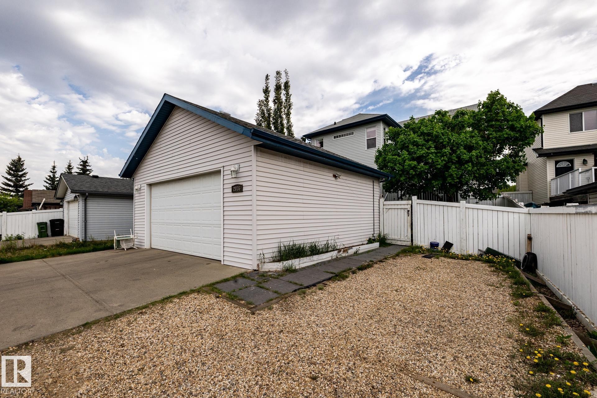 Detached garage with white horizontal siding and a blue-trimmed gable roof - 2036 Towne Centre Boulevard, Edmonton, AB - Outdoor