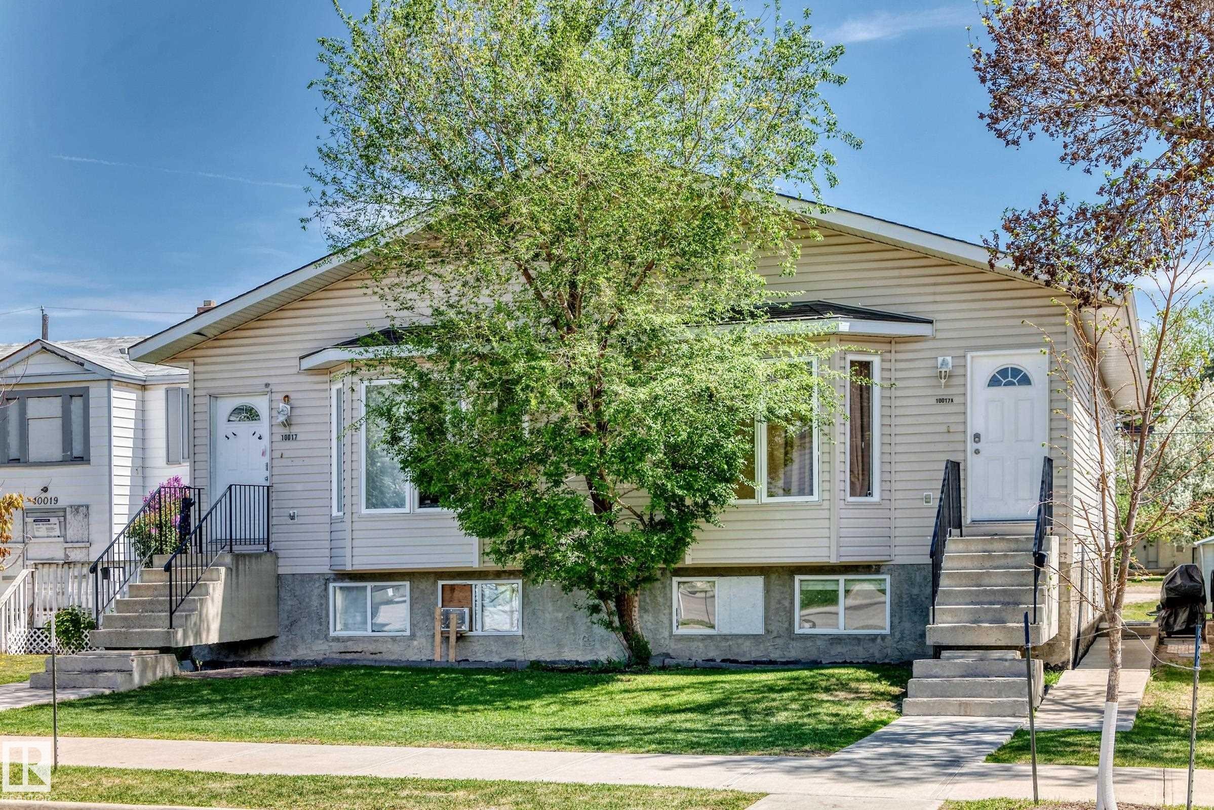 Duplex property featuring light-colored horizontal siding and a prominent bay window - 10017 153 Street, Edmonton, AB - Outdoor With Facade
