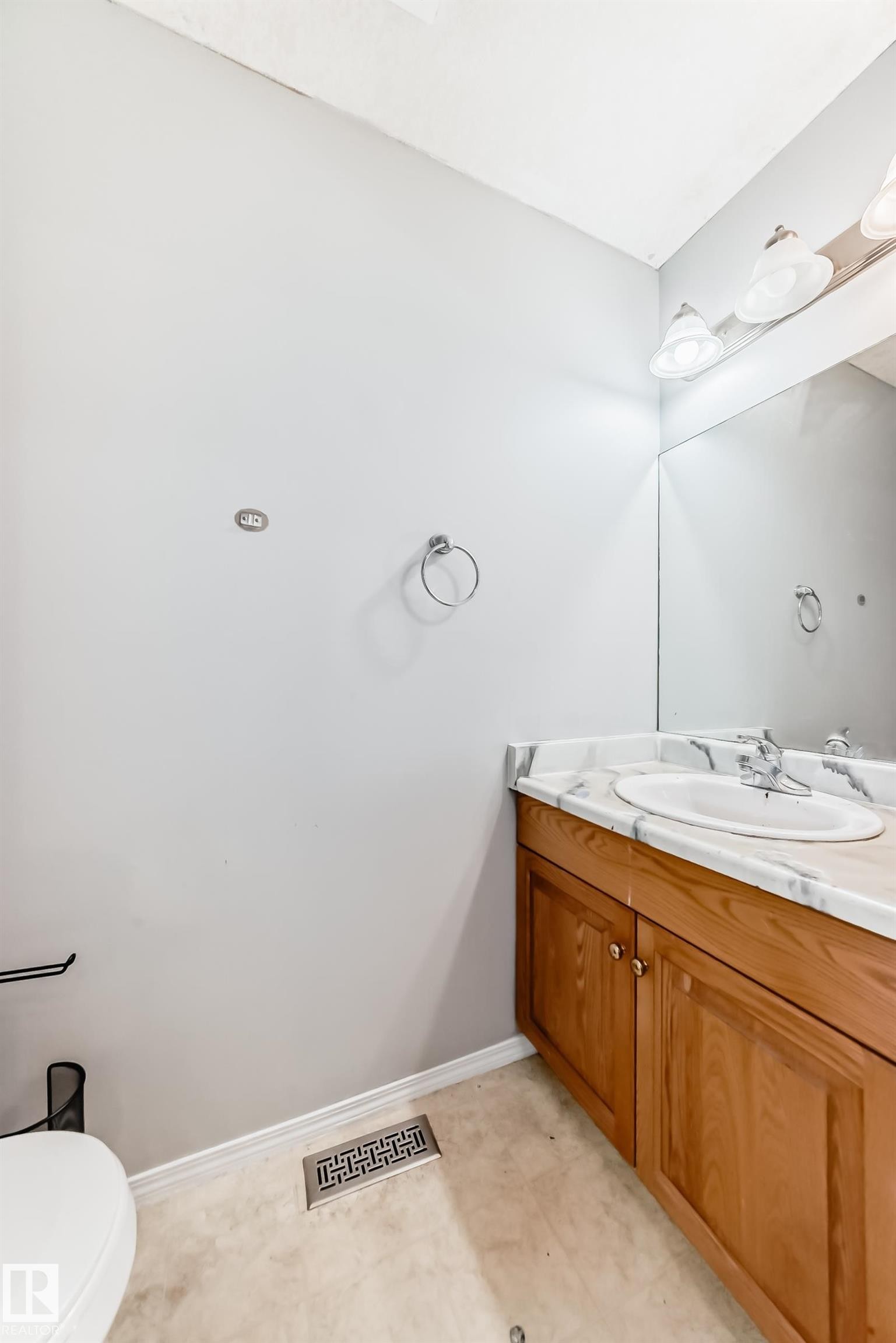 Light-toned vanity with an integrated sink, a white countertop with gray veining, and a large wall-mounted mirror with overhead lighting - 10017 153 Street, Edmonton, AB - Indoor Photo Showing Bathroom