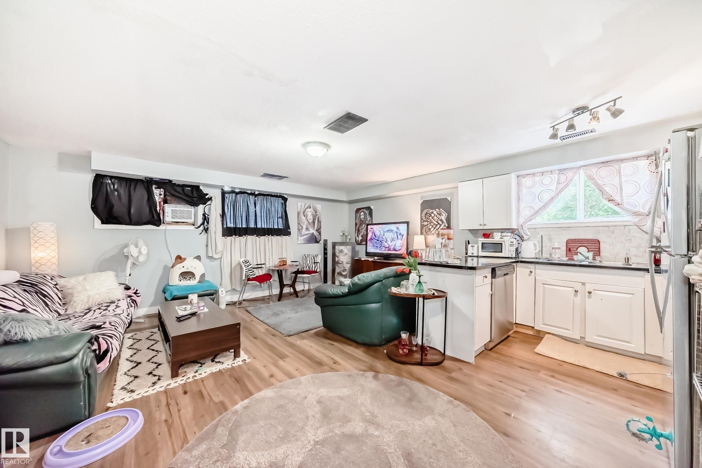 Open-concept living space featuring wood-finish flooring, recessed lighting, and a neutral wall color - 10017 153 Street, Edmonton, AB - Indoor