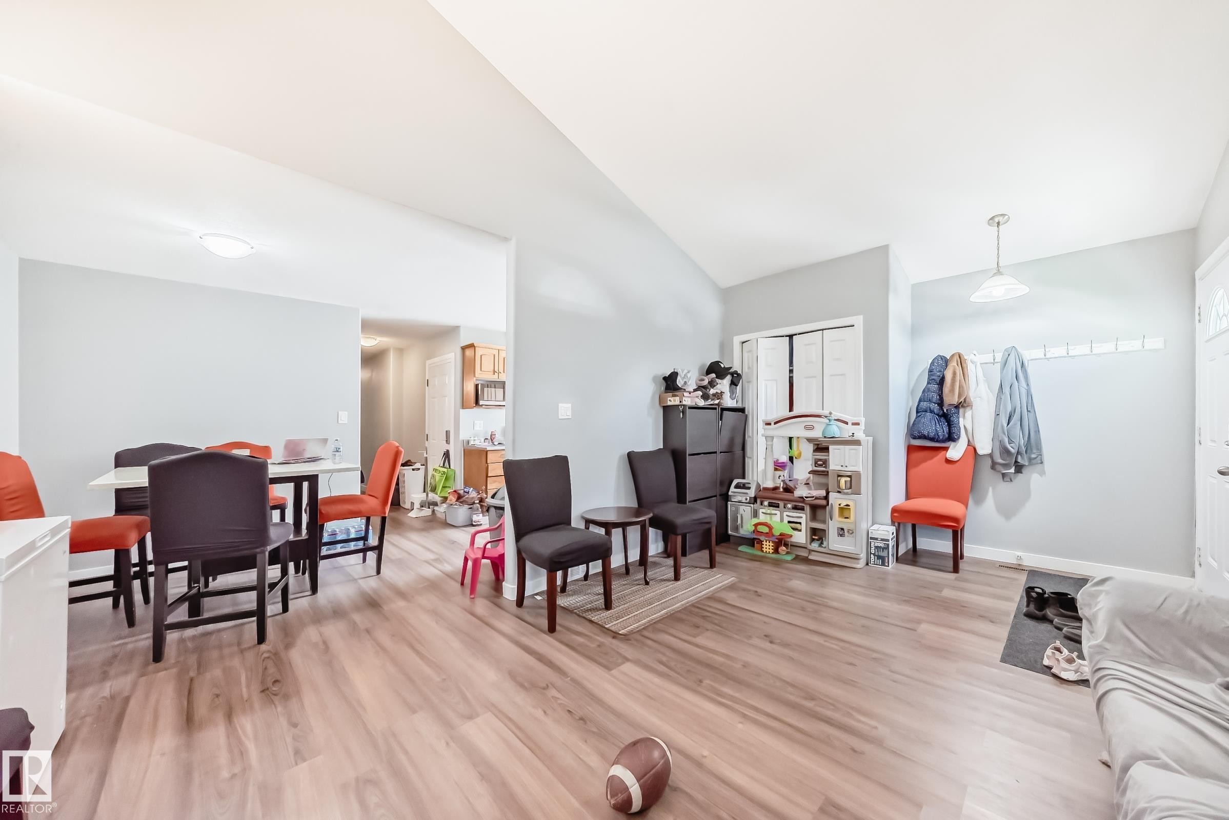 Open-concept living area with wood-finish flooring, light grey wall paint, and white trim - 10017 153 Street, Edmonton, AB - Indoor